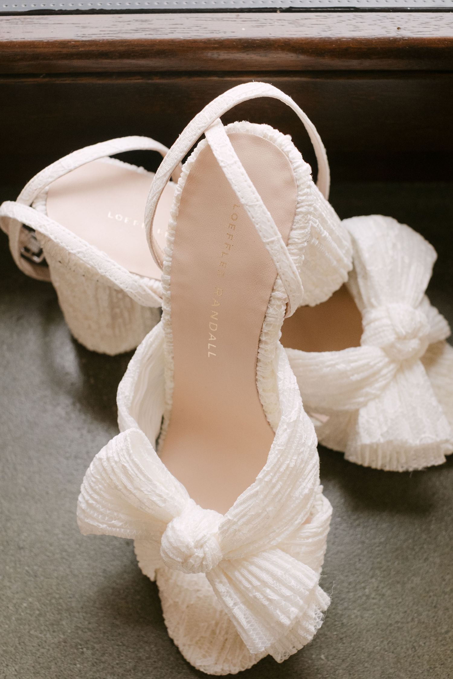 Elegant white bridal shoes with delicate ruffled details arranged in a sequence.