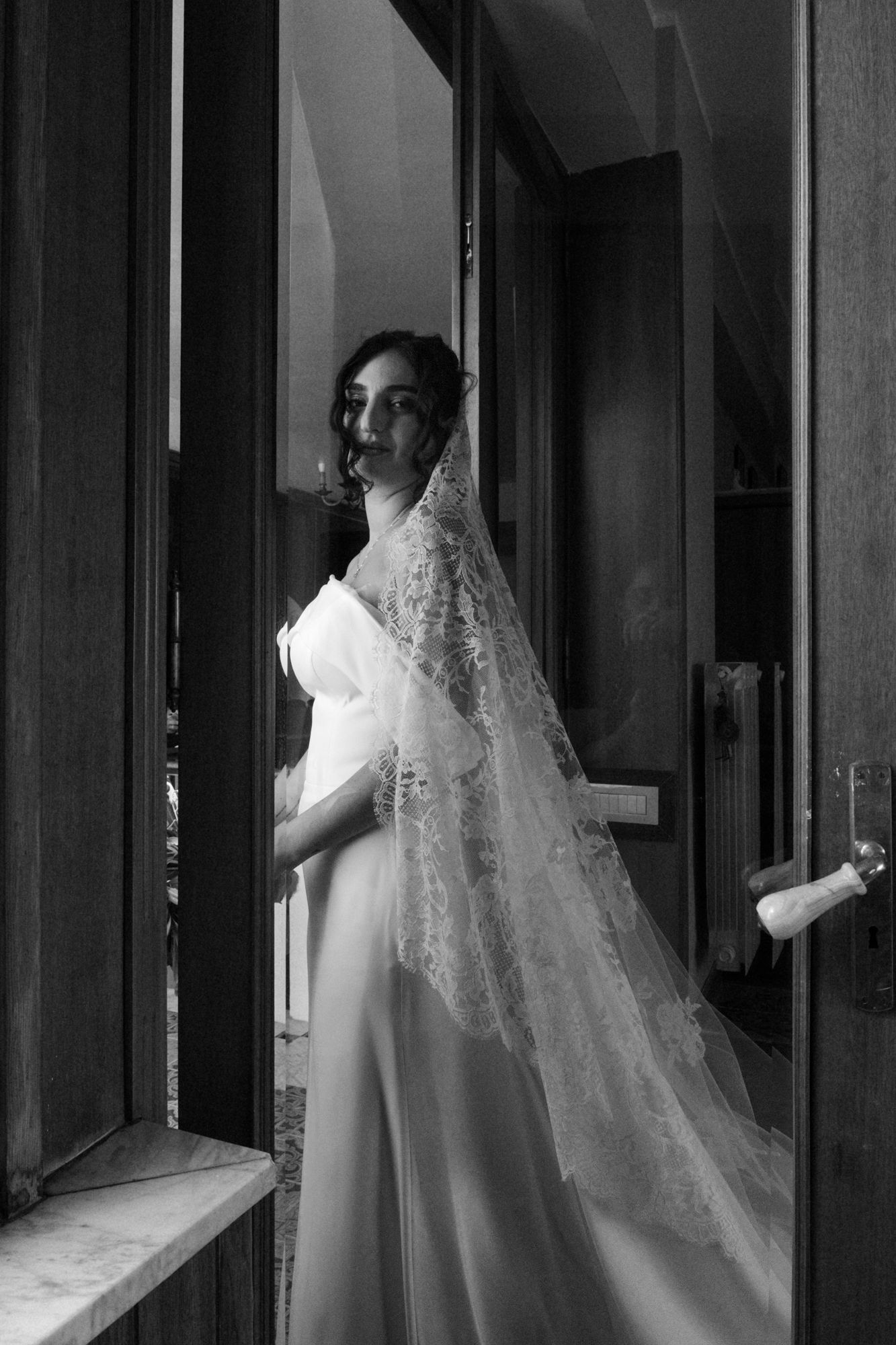 A series of black and white photos showing a bride in an elegant white wedding dress with a flowing veil.