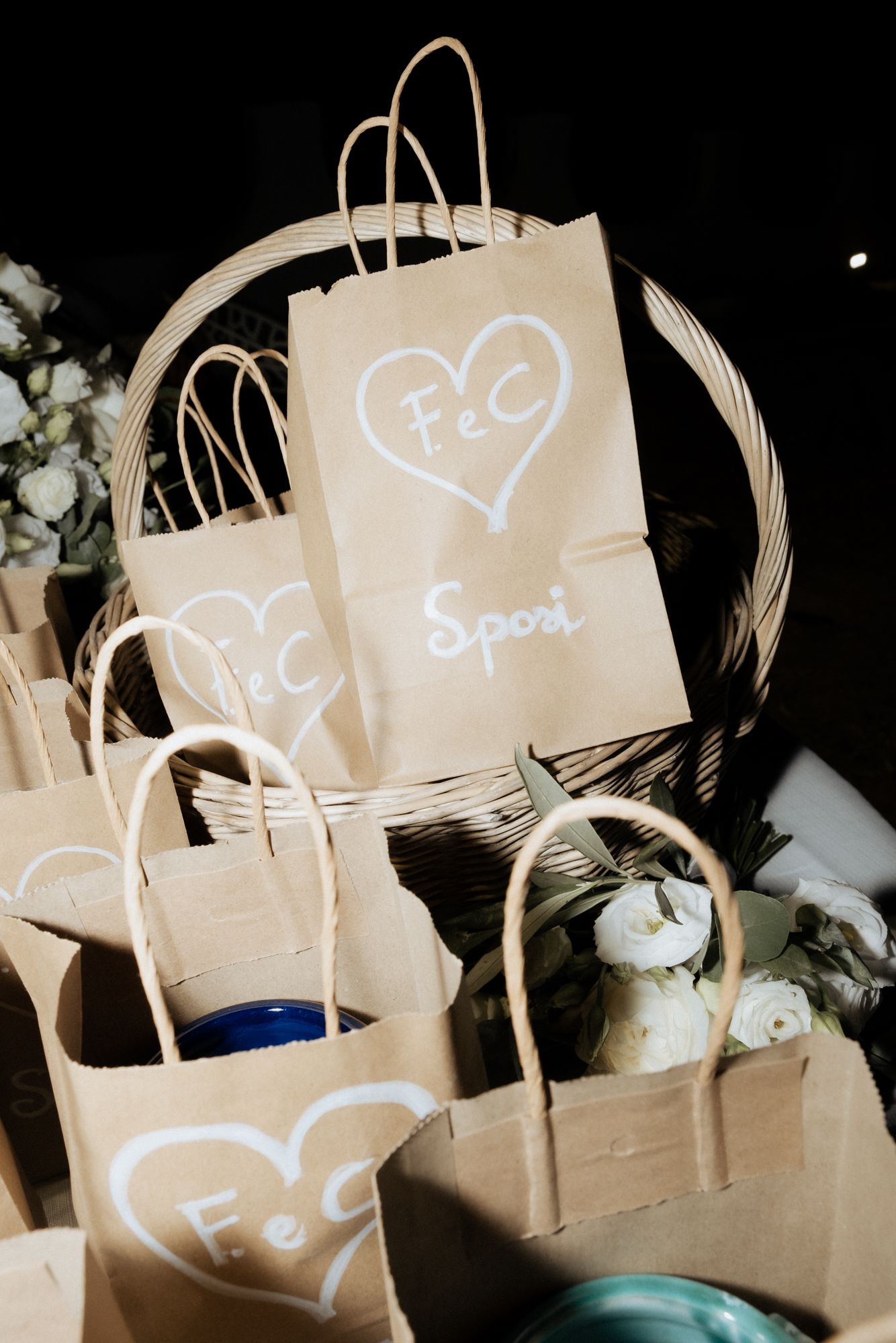 Brown paper gift bags with white heart drawings arranged in dark setting.