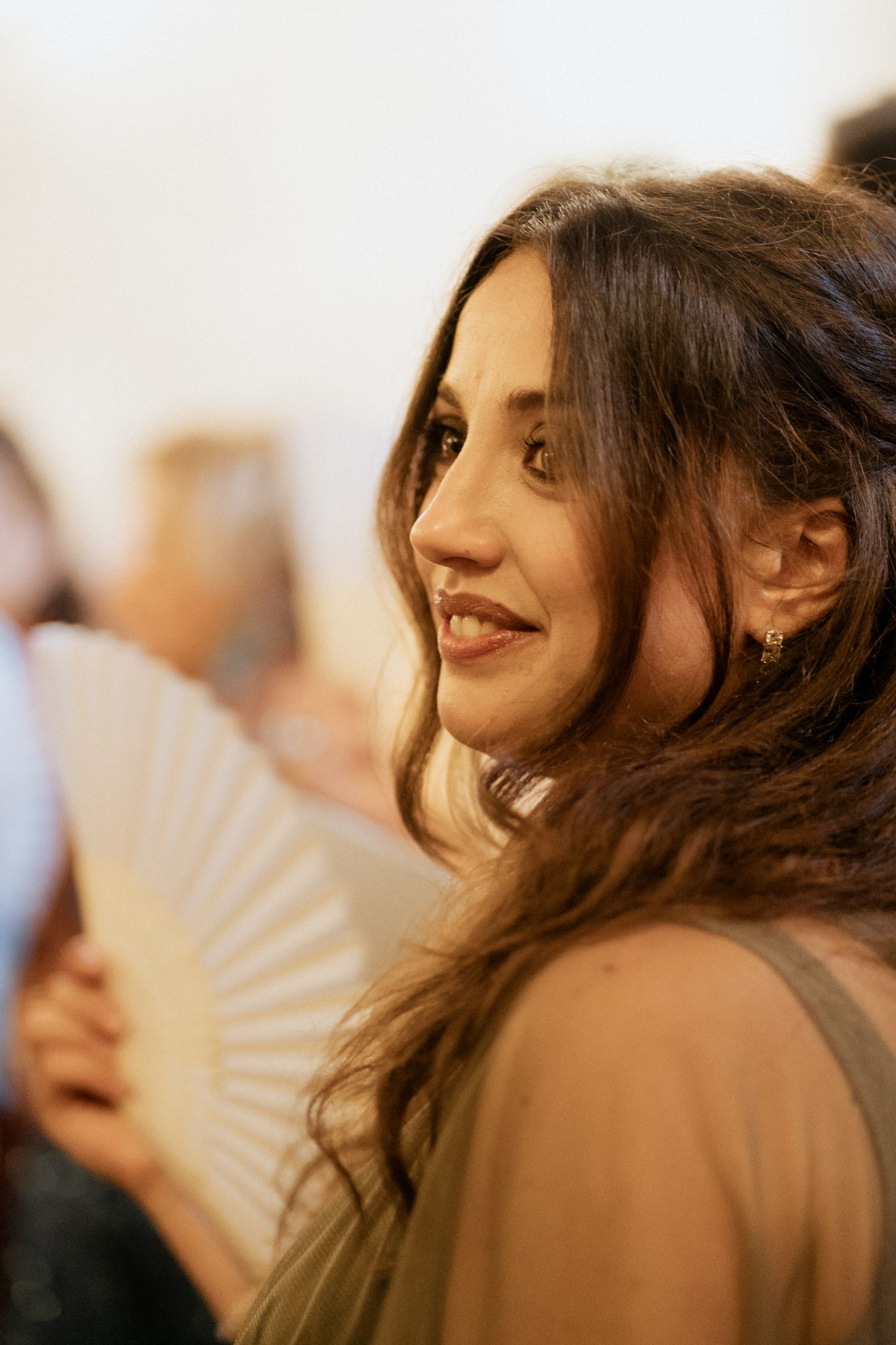 Wedding guests enjoying the celebration with decorative paper fans.
