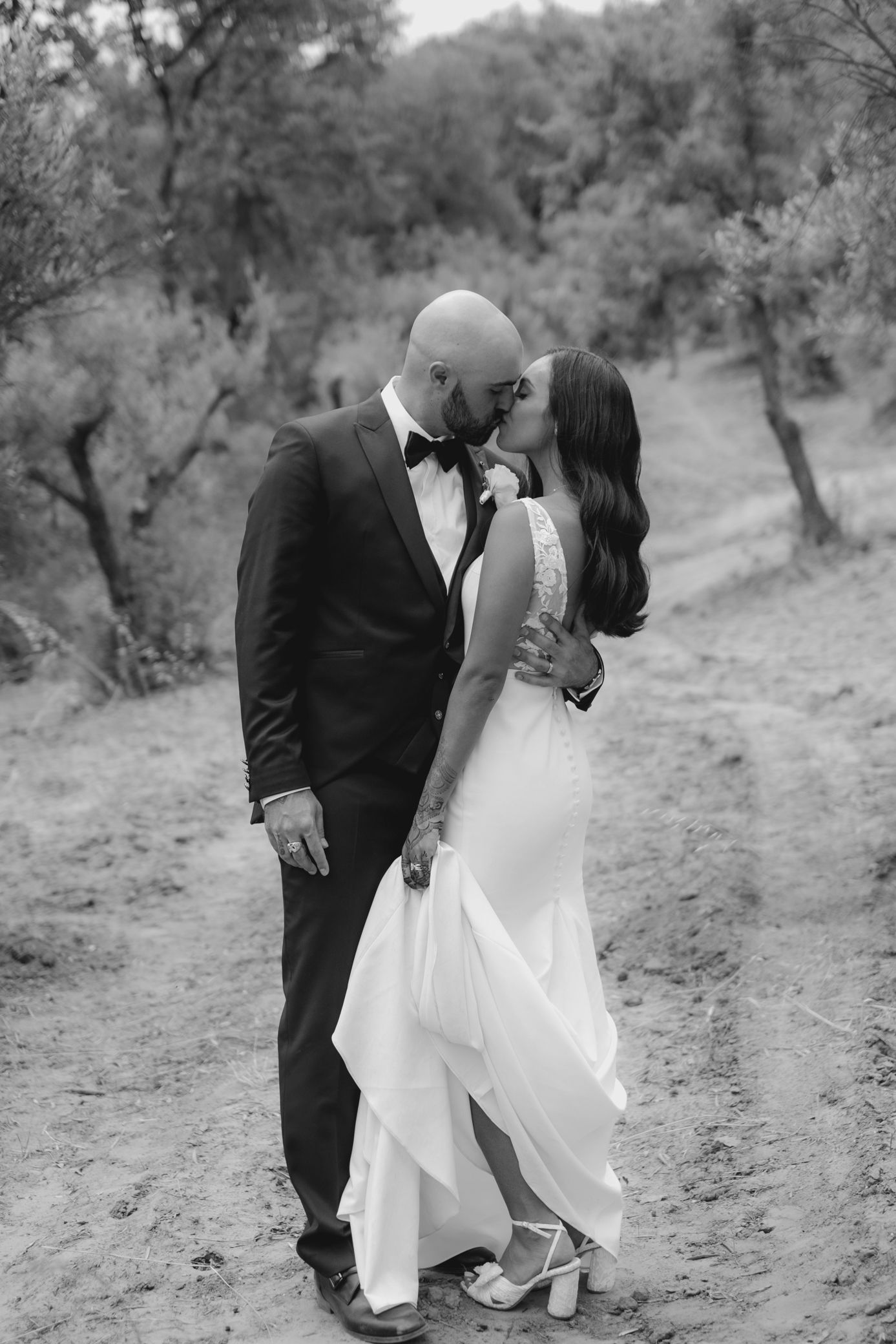A romantic black and white wedding photo sequence shows a couple in formal attire sharing intimate moments on a hillside path.
