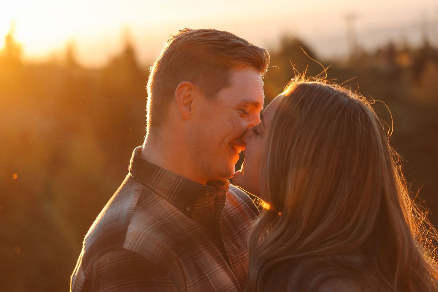 Intimate couple portrait backlit by warm sunset glow.