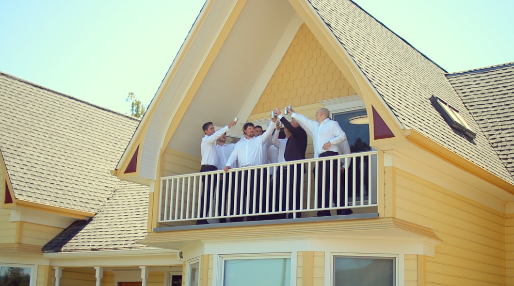 Yellow craftsman-style house exterior with white trim and balcony details.