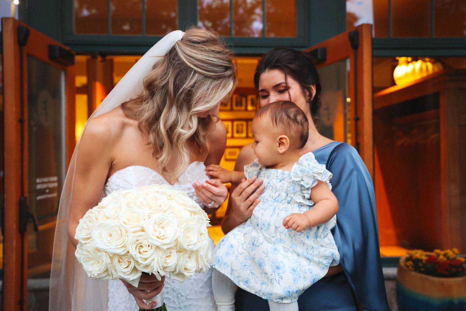 Wedding moment with couple and baby in formal attire.