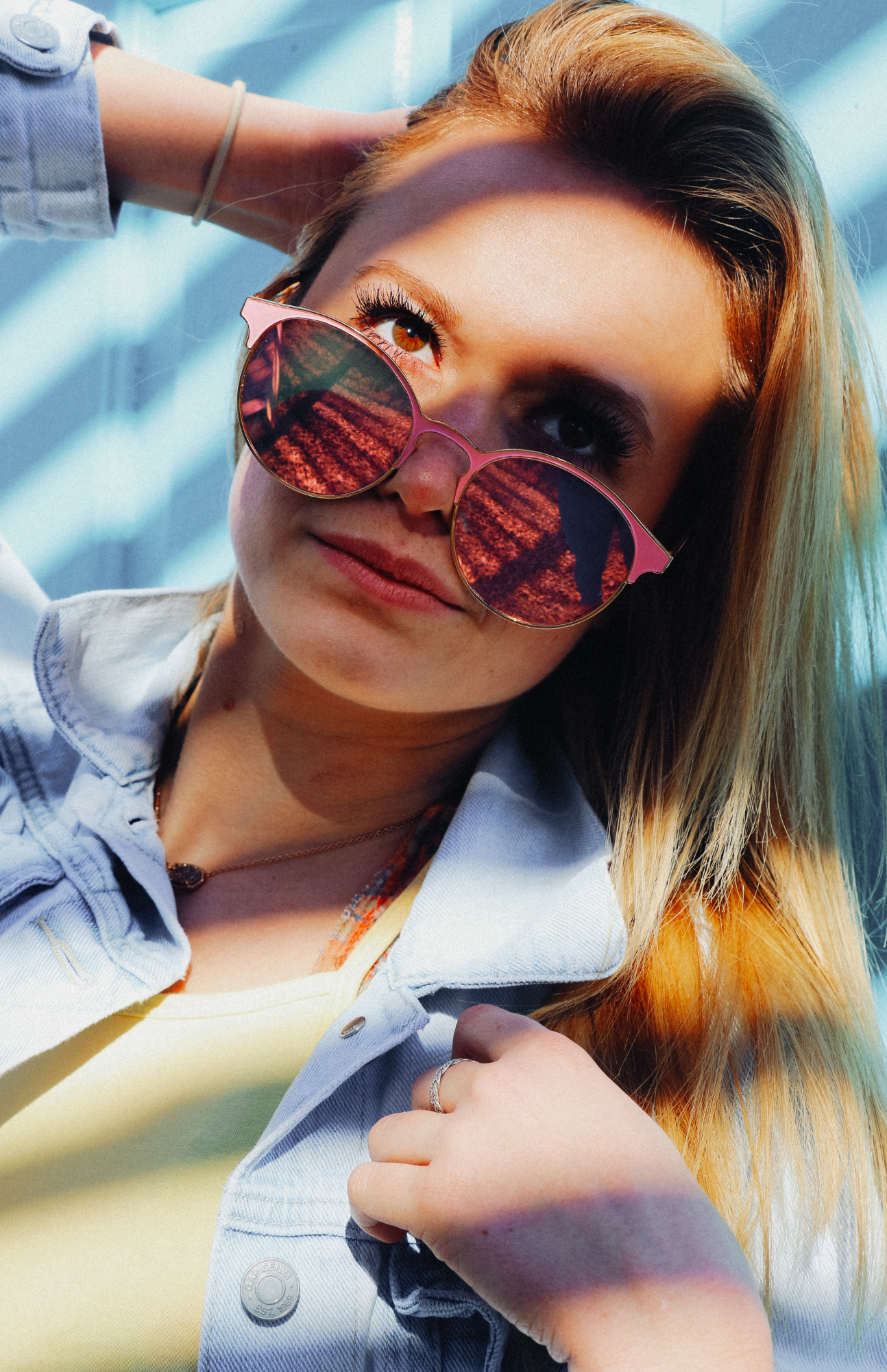 Woman wearing pink sunglasses poses playfully in multiple selfie-style shots with bright lighting.