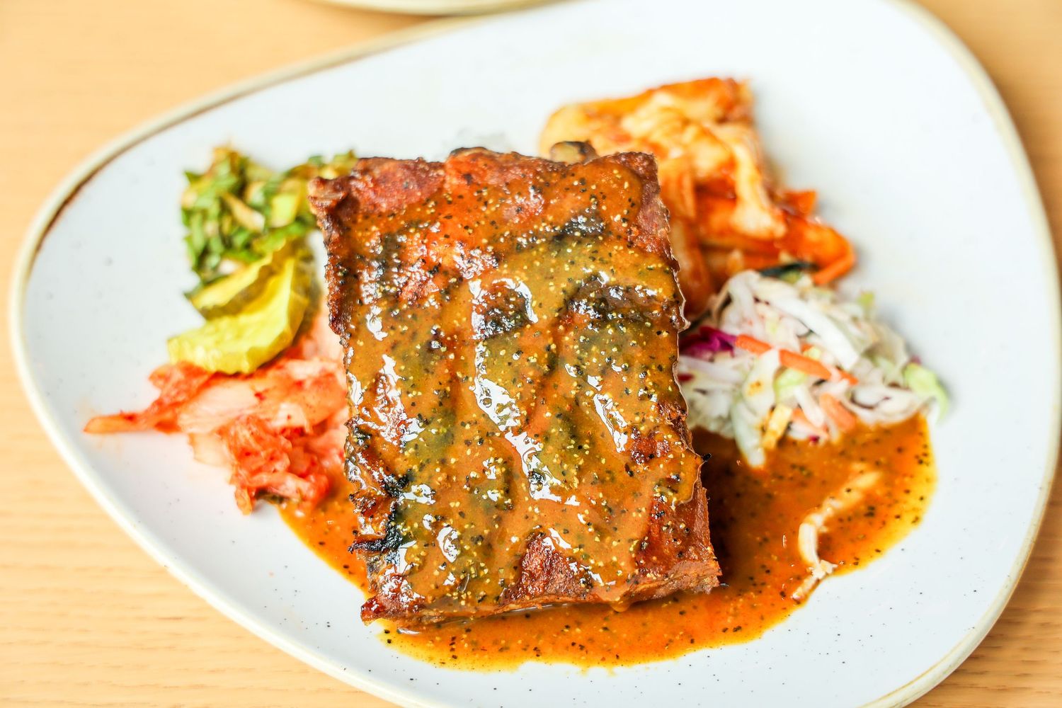 Grilled fish fillets with vibrant sauces and garnishes on white plates.