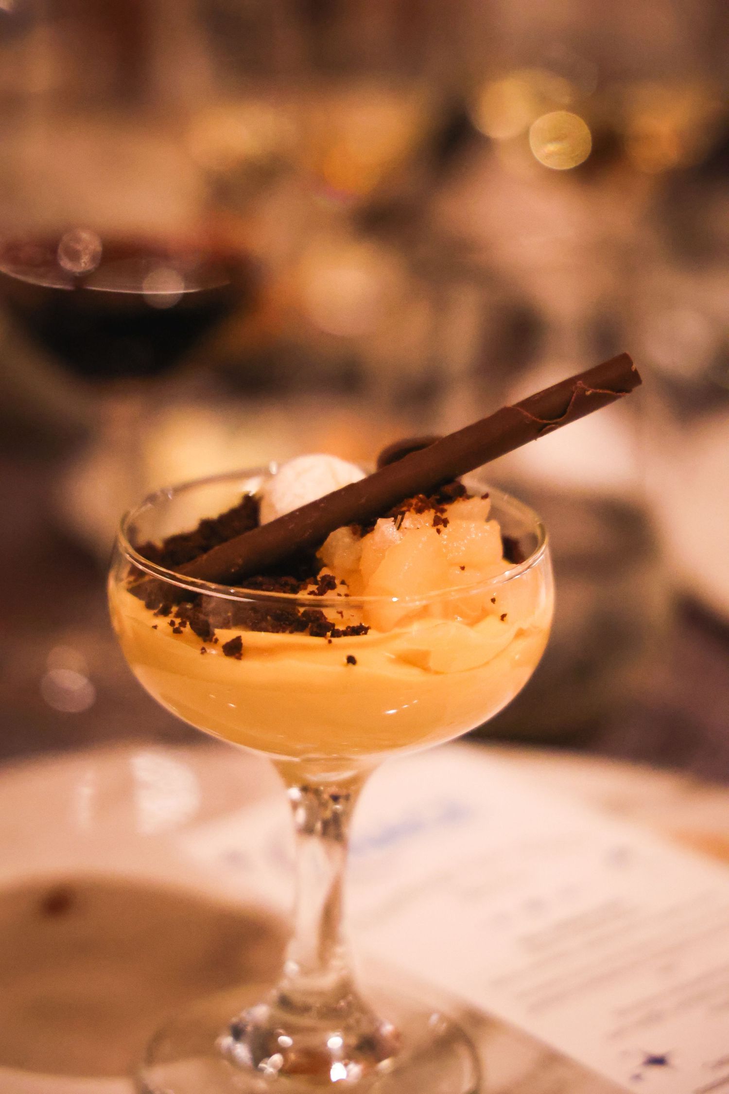Creamy cocktail garnished with cinnamon stick in coupe glass.