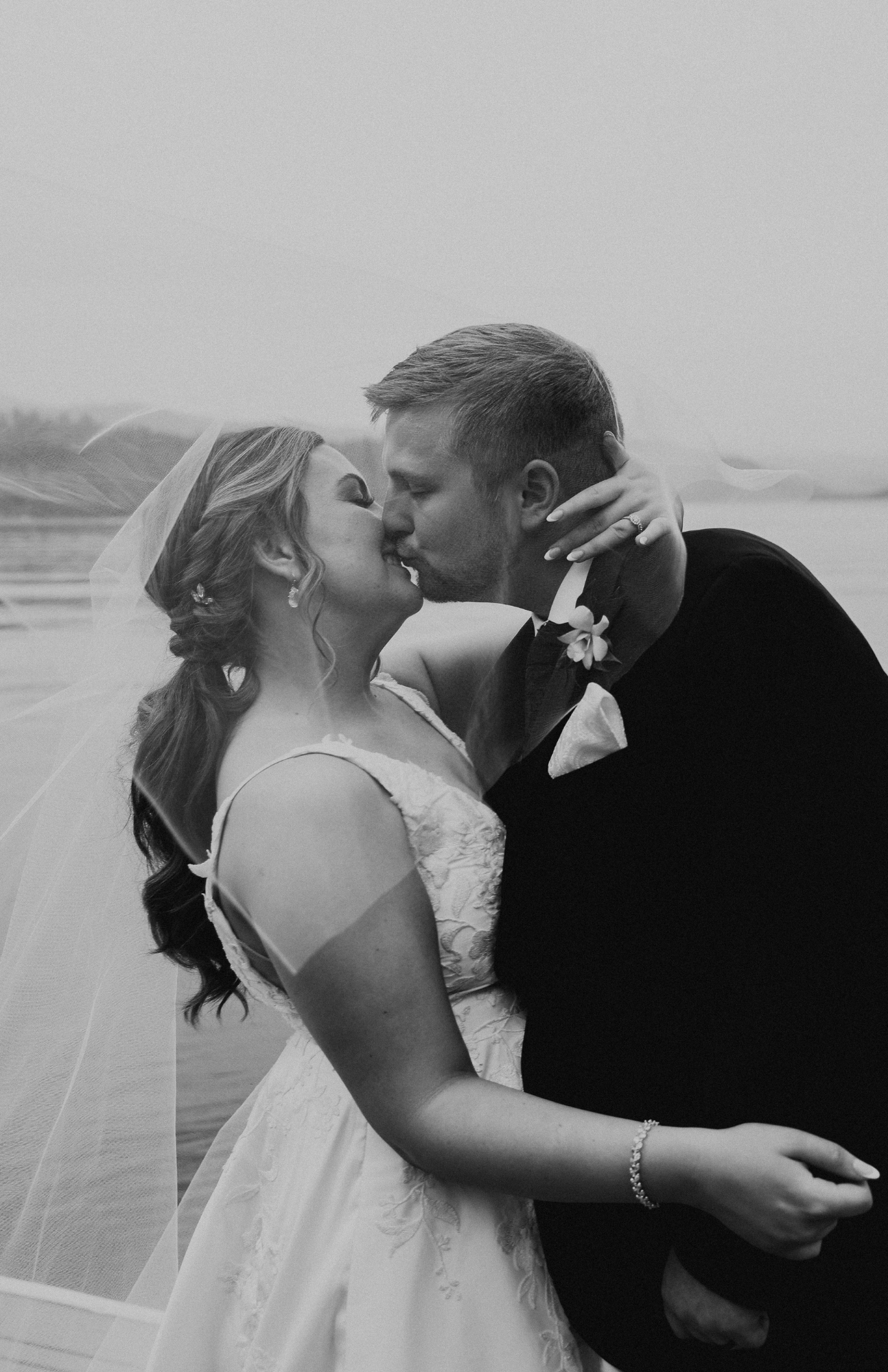 A series of romantic wedding kiss photos in black and white.