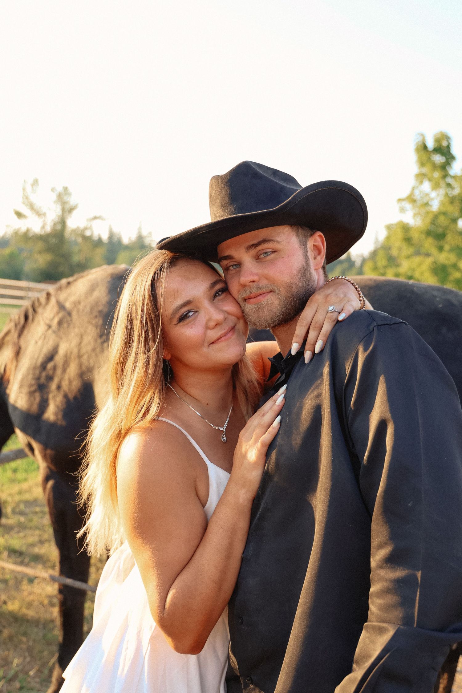 Sunset photoshoot with couple in western wear near horses.