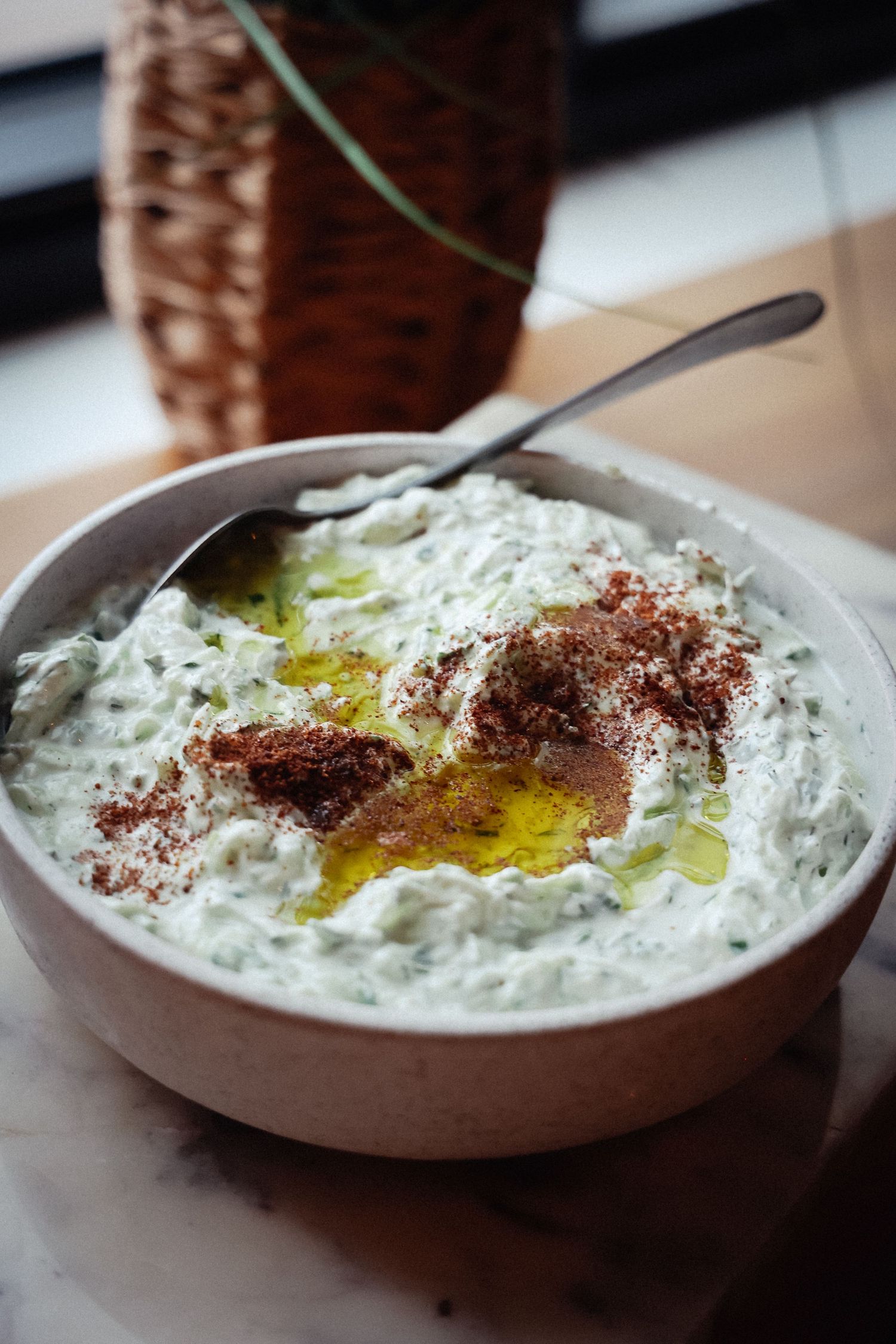 Creamy white dip garnished with olive oil and spices in a shallow bowl.