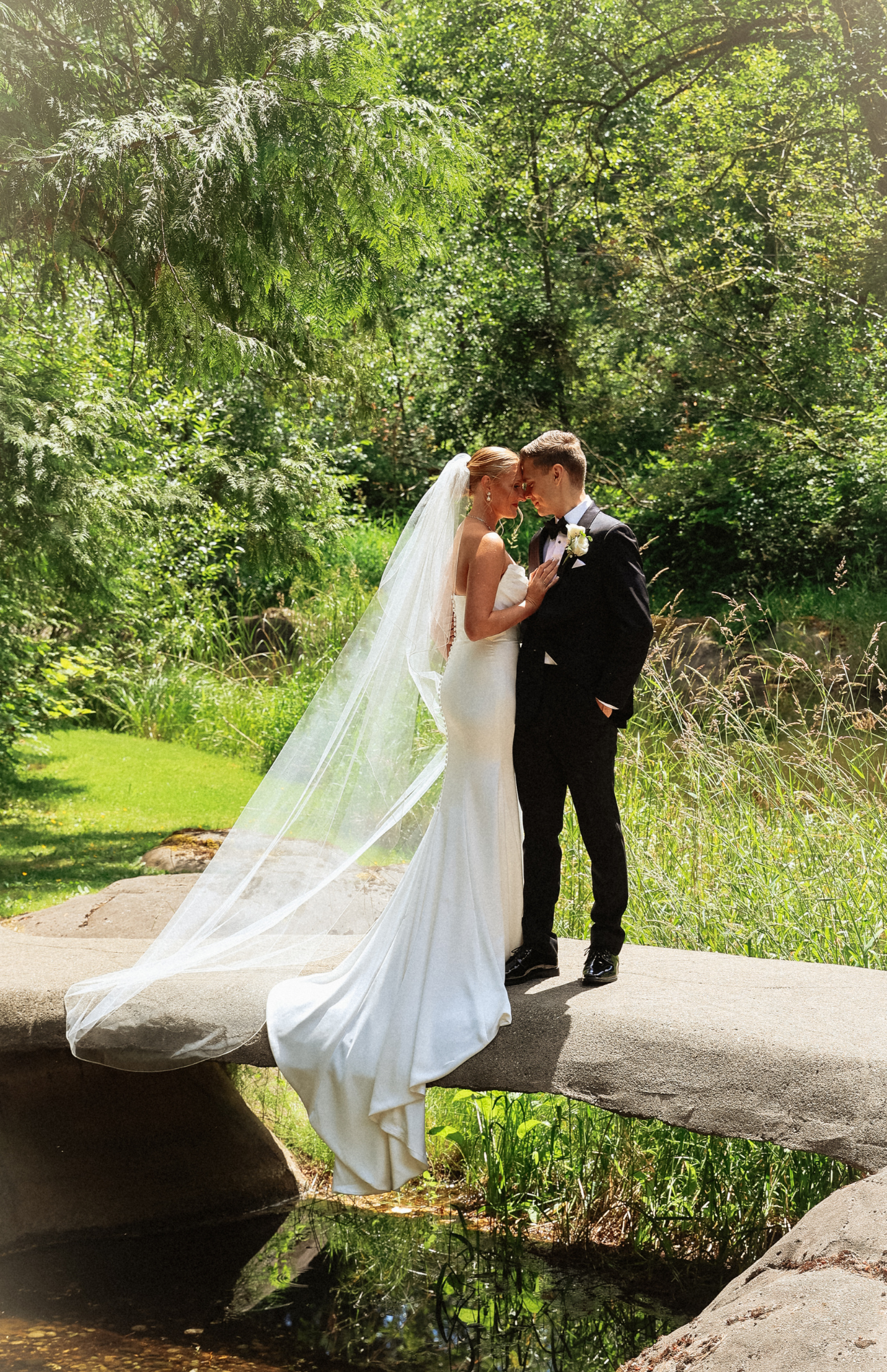A wedding couple sharing romantic moments in a lush garden setting.