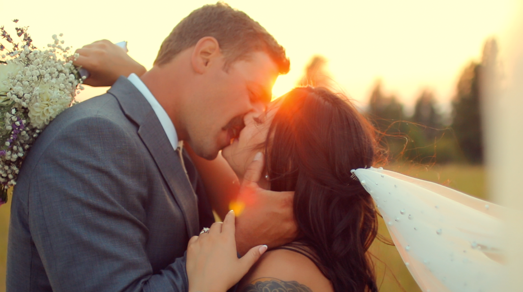 Intimate moment shared during sunset at an outdoor wedding celebration.