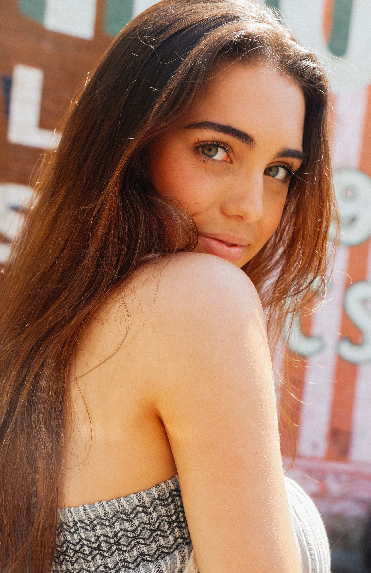 Portrait sequence of someone looking over their shoulder in a patterned top.