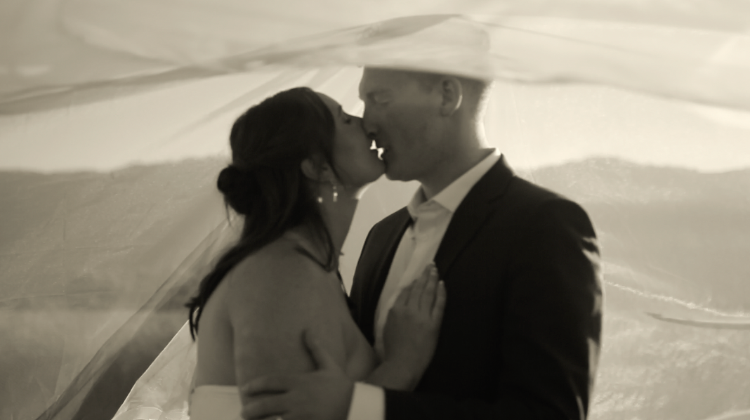 Black and white artistic wedding portrait with flowing veil.