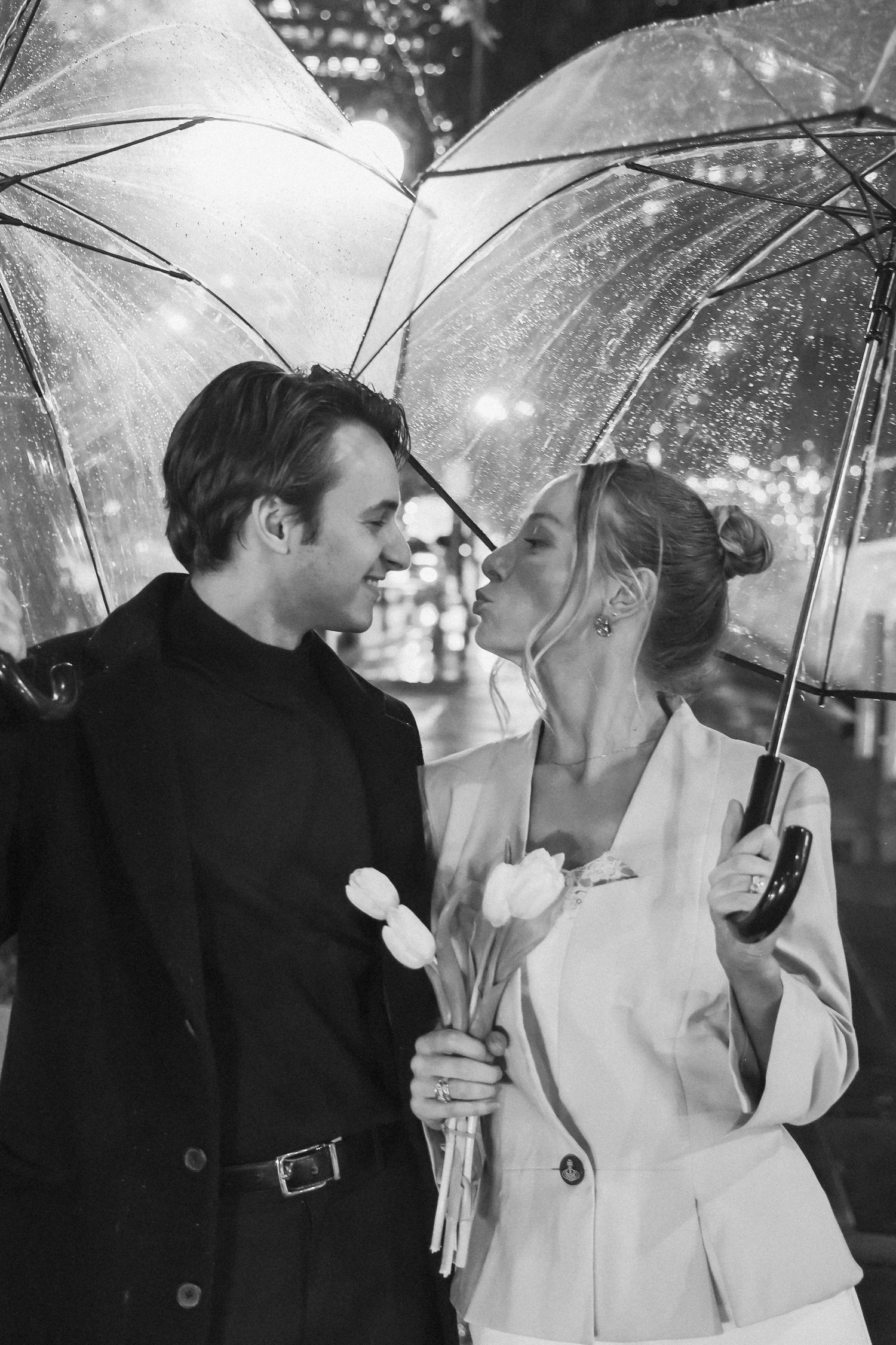 Romantic black and white photo series of couple sharing umbrella in the rain.