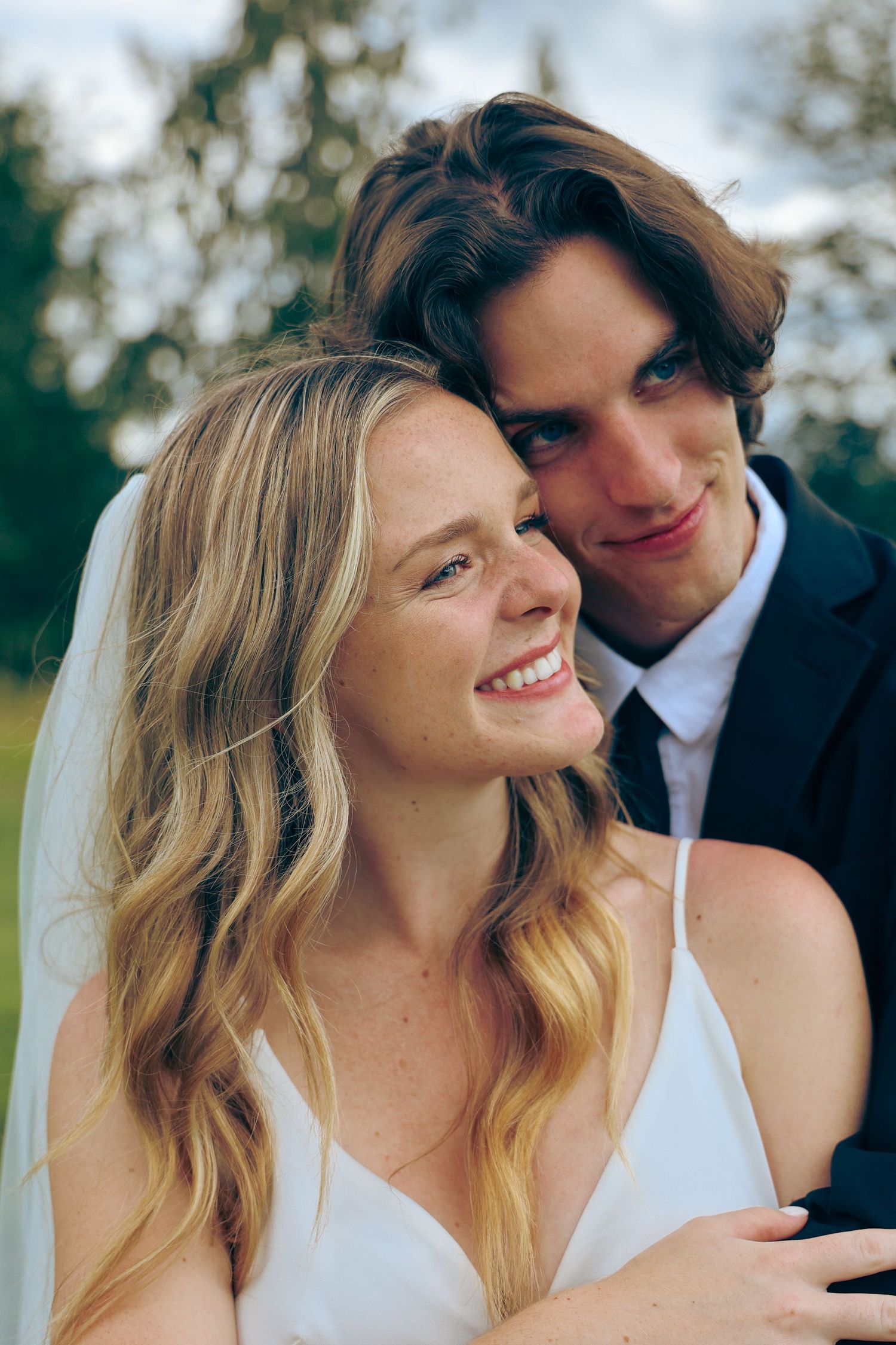 A romantic outdoor wedding photo series showing close-up shots of a couple in white attire with natural lighting.