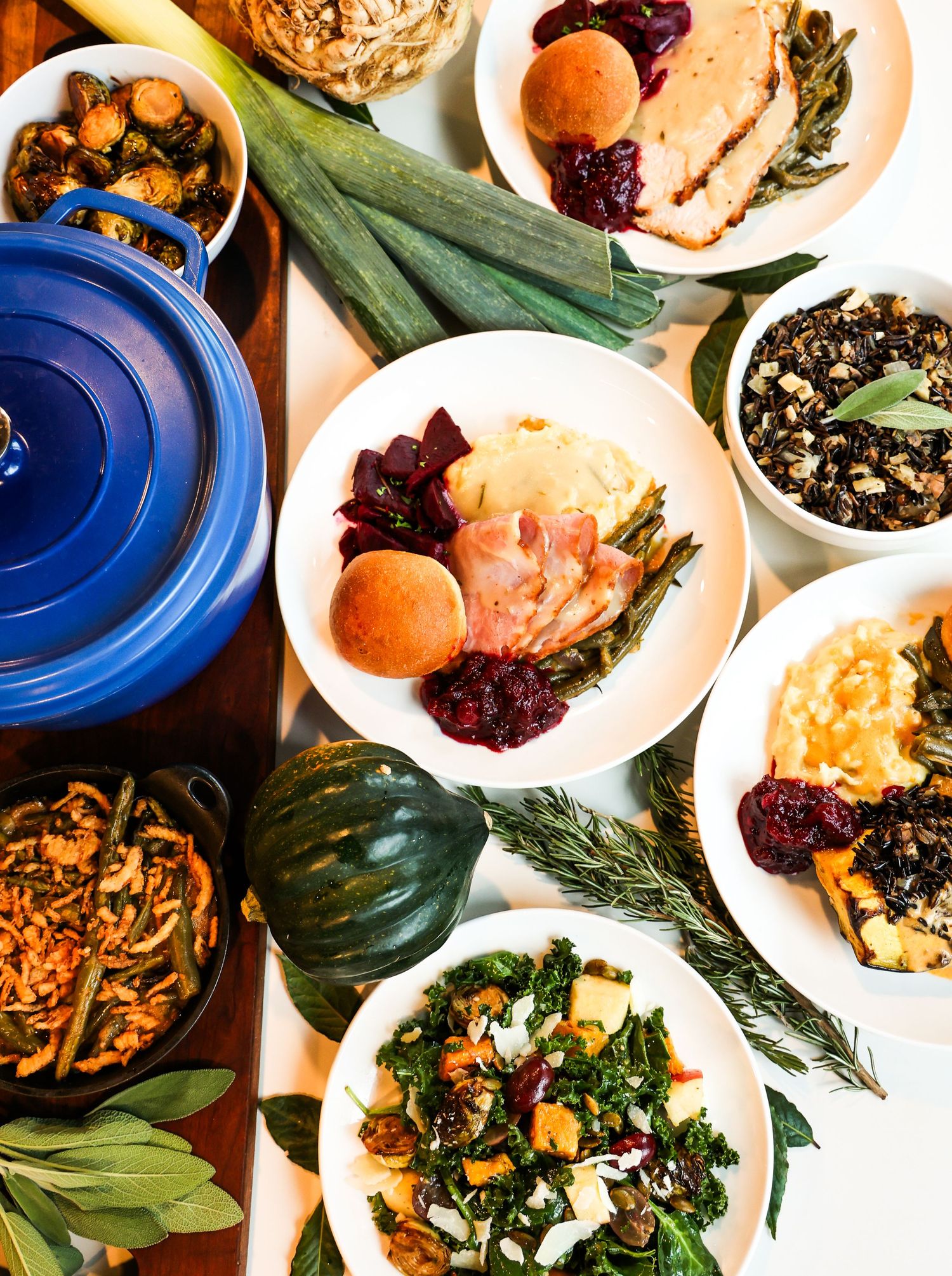 Overhead view of harvest dinner spread with roasted vegetables and blue Dutch oven.