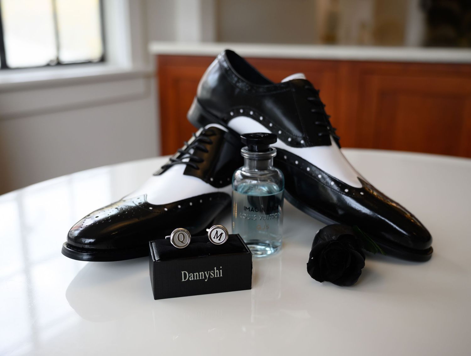 A collection of black leather dress shoes and accessories arranged on a white surface.
