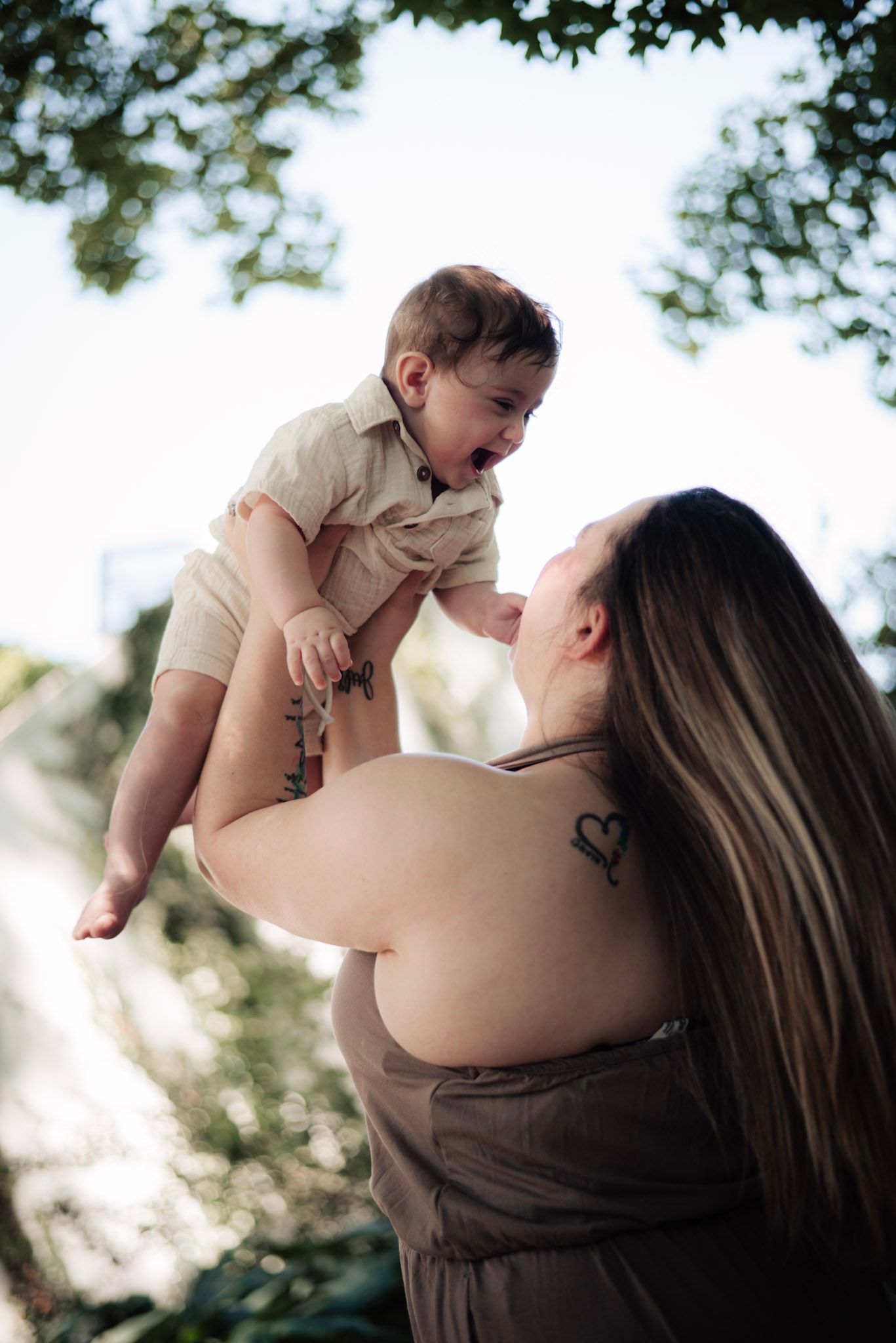 Joyful interaction between parent and child outdoors in natural lighting.