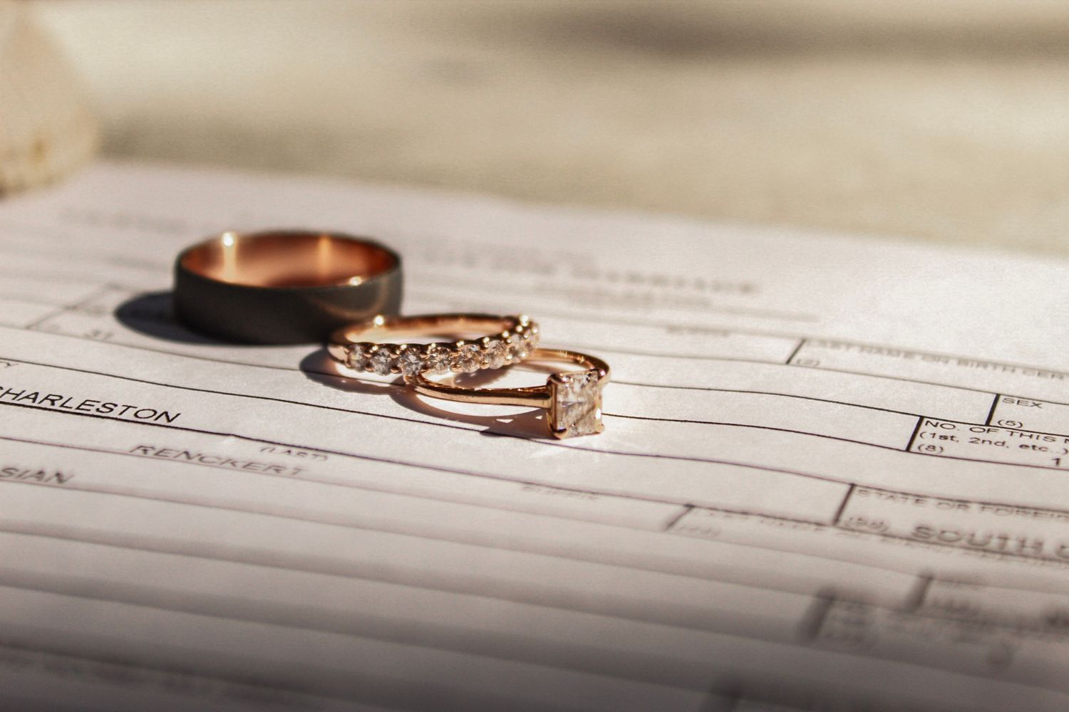 Wedding rings and paperwork arranged for detail photography.