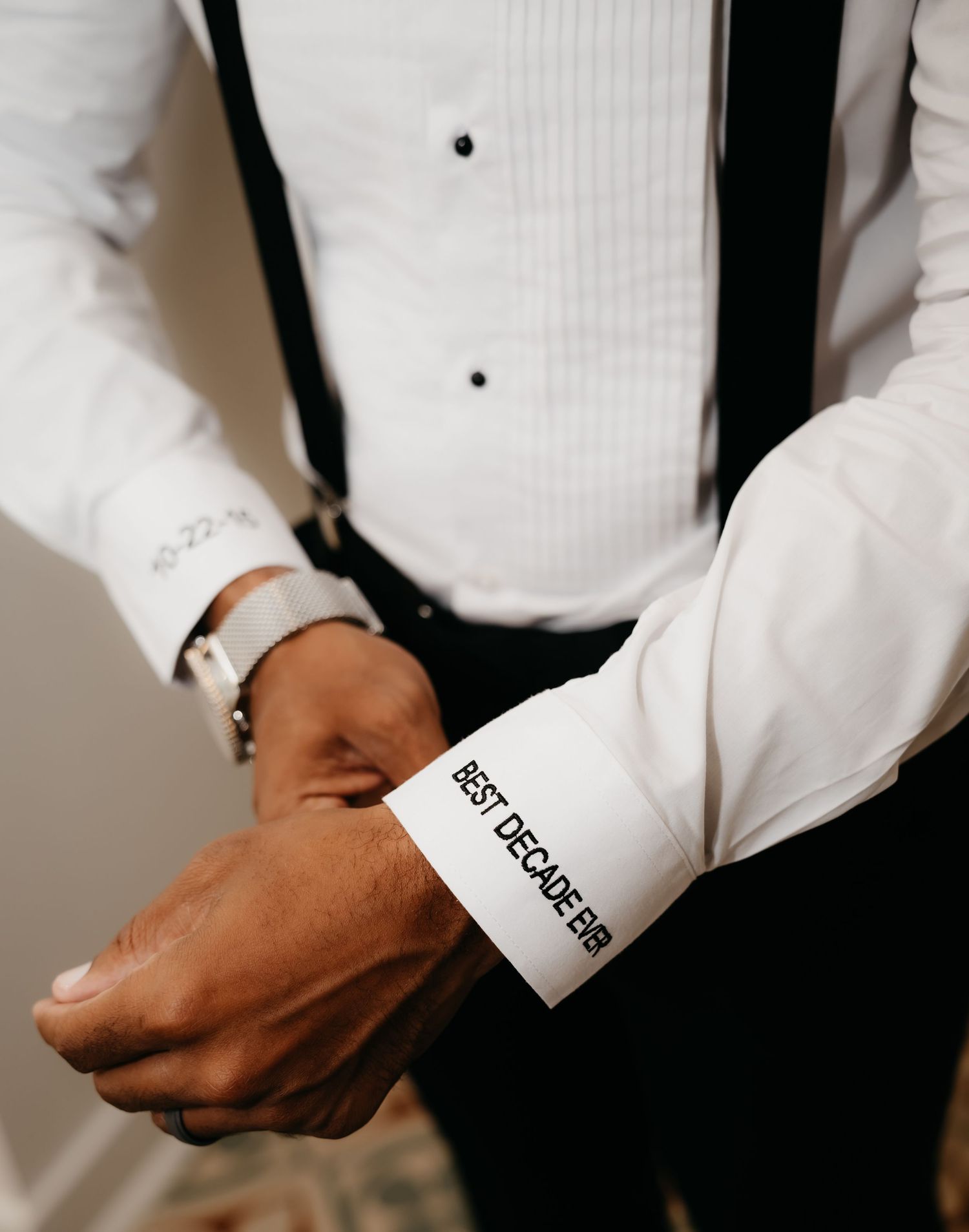 Close-up shots of formal white dress shirt cuffs with text details in a wedding preparation sequence.