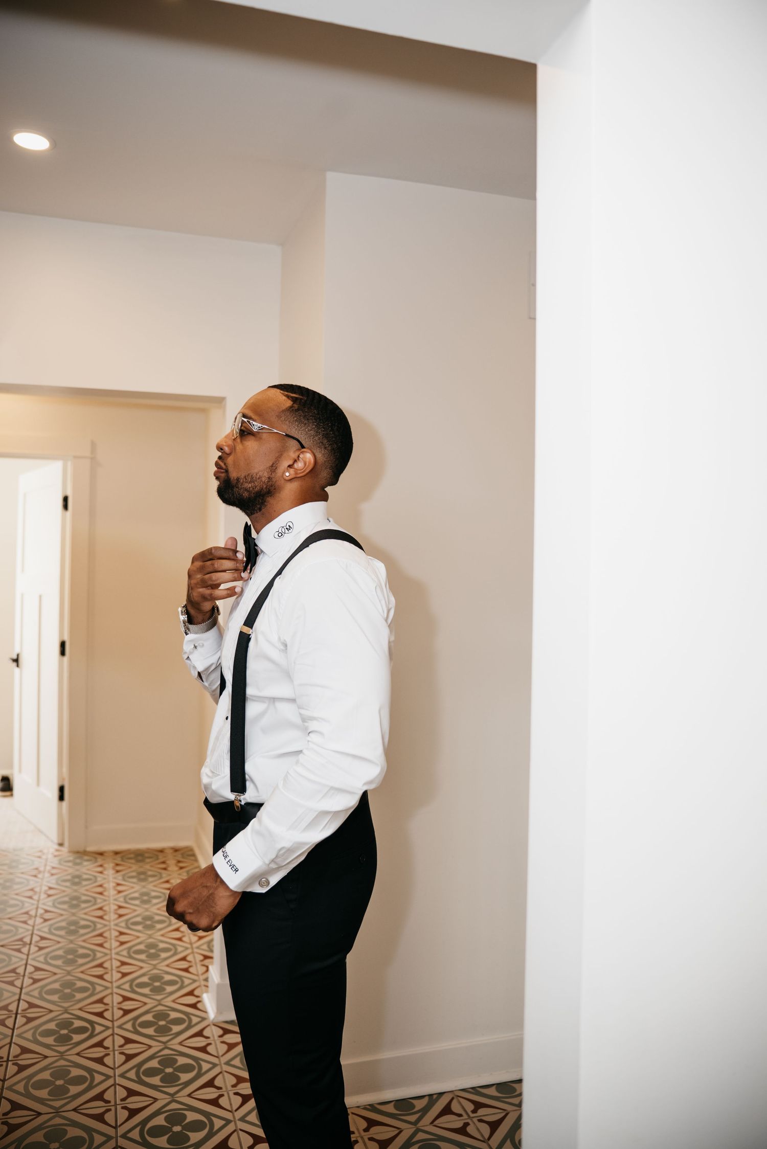 Wedding preparation scene showing formal attire against white interior walls and patterned flooring.