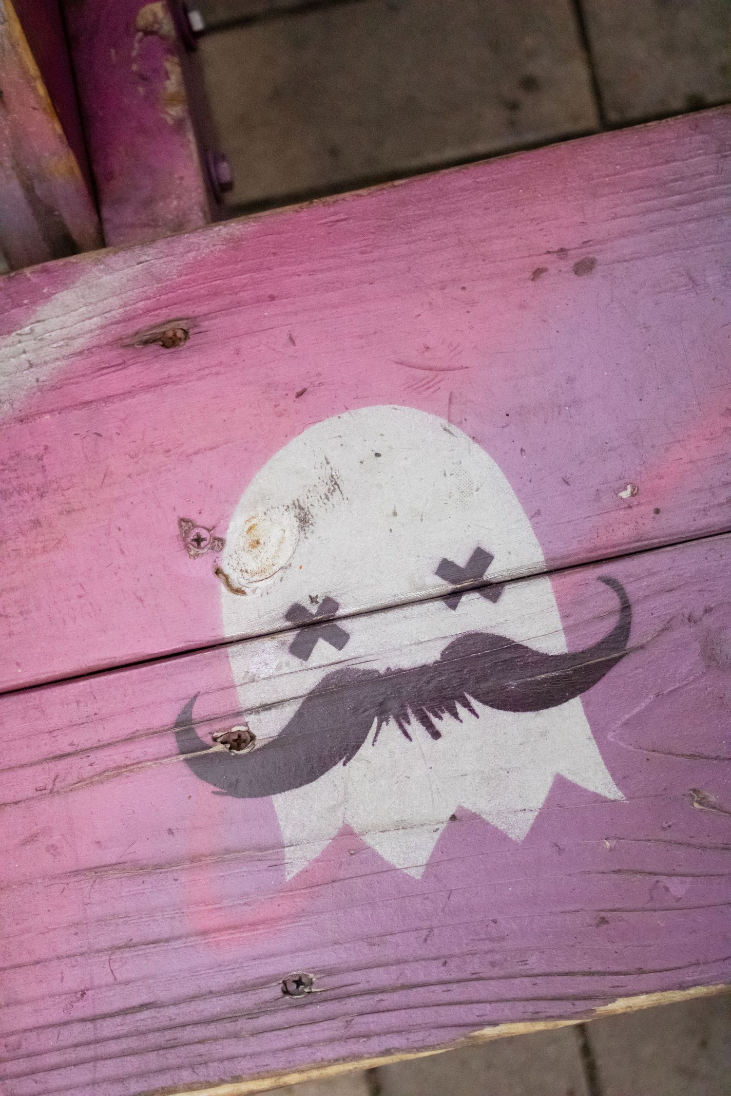 A sequence of pink wooden panels showing a decorative black and white bird silhouette painted across multiple boards.