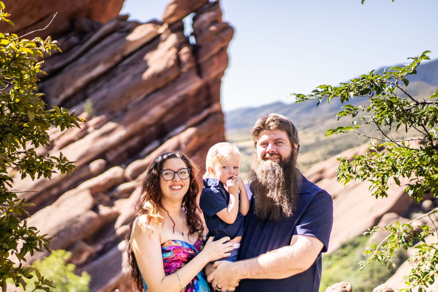 A couple shares a joyful moment together while hiking among red rock formations in a scenic desert landscape.