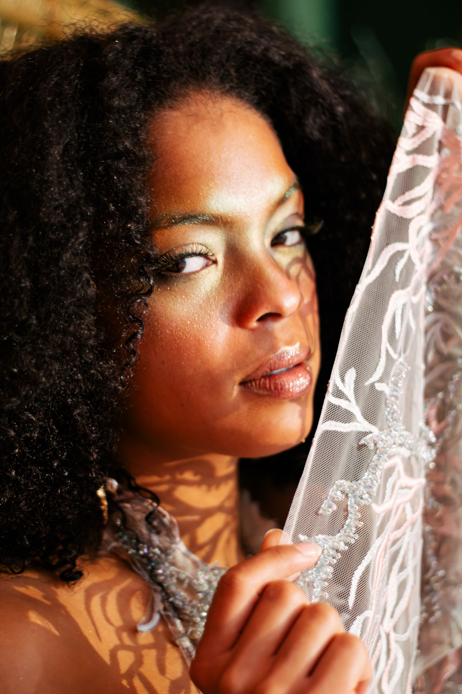 A portrait series showing a person with natural curly hair posing with dramatic lighting and shadow patterns.