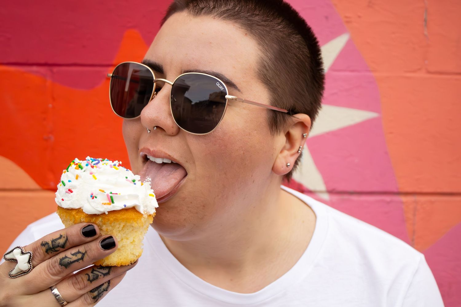 A person enjoying an ice cream cone against a vibrant pink and orange background in a series of close-up shots.