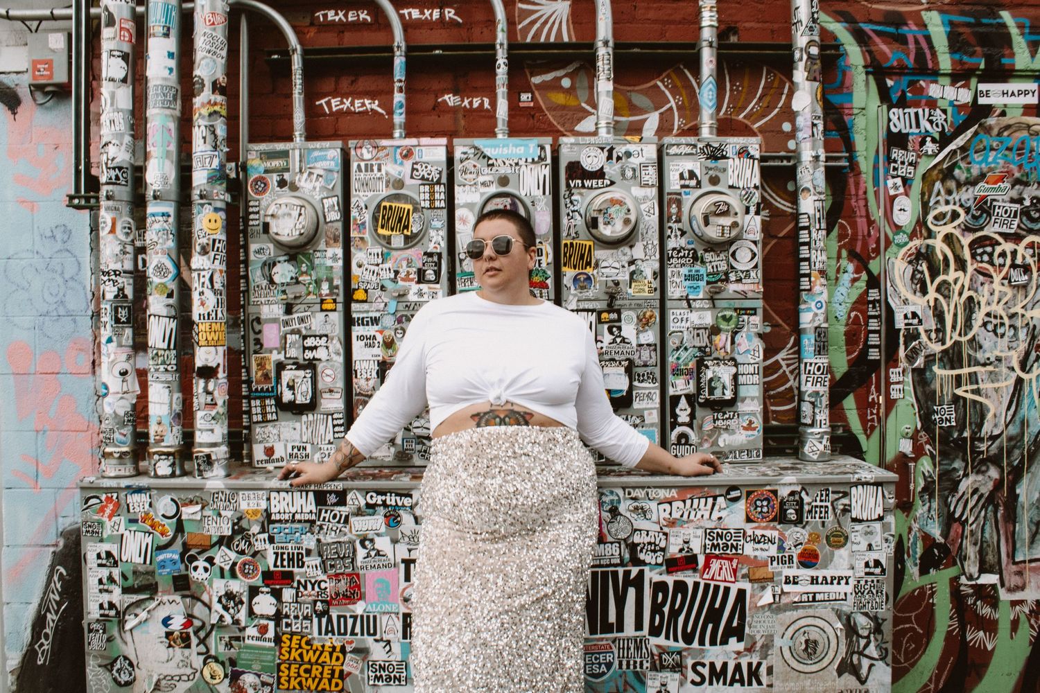 A graffiti-covered wall with colorful street art and tags creates an urban backdrop.