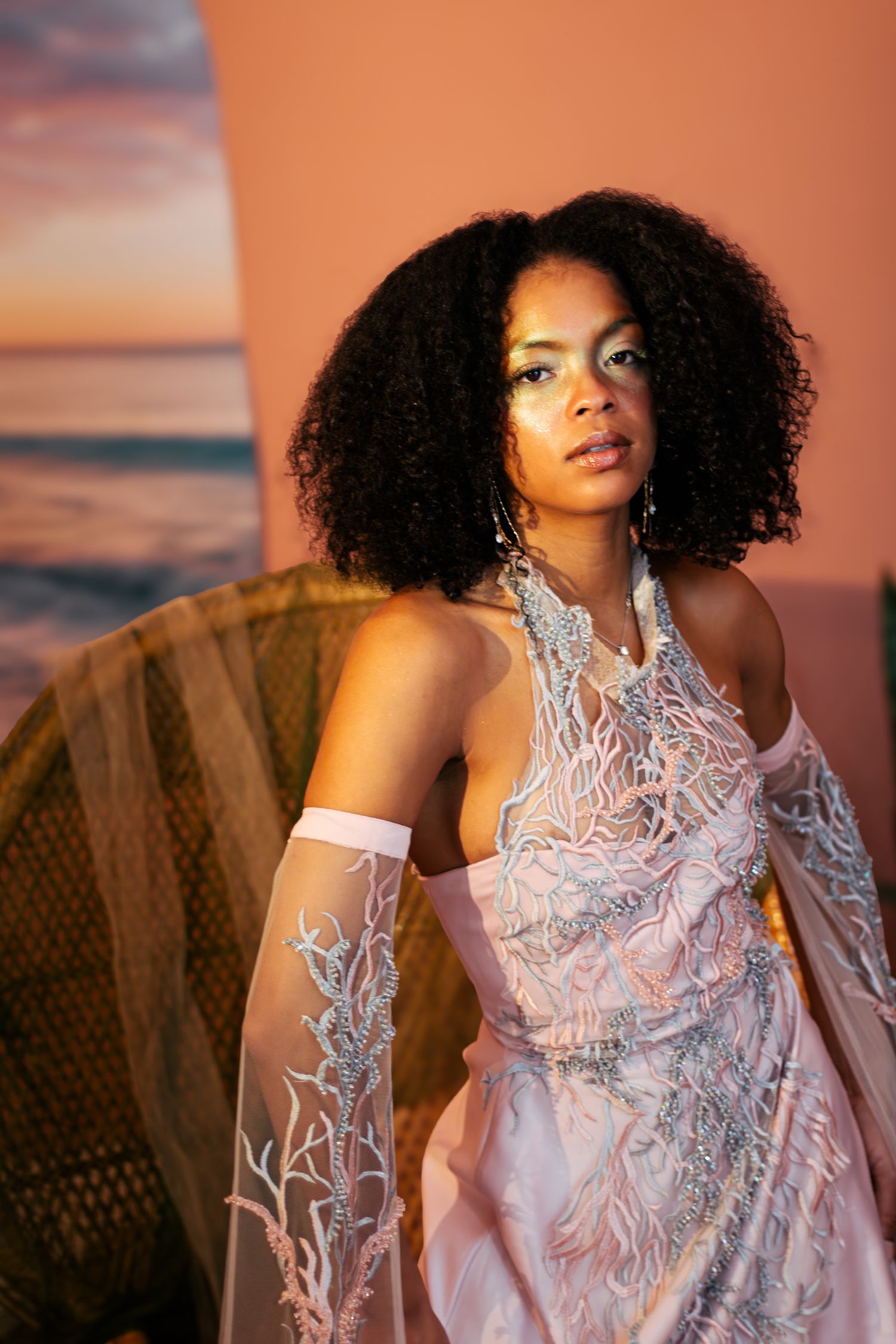 A series of sunset portraits showing a figure in a white lace dress with natural curly hair against a warm orange sky.