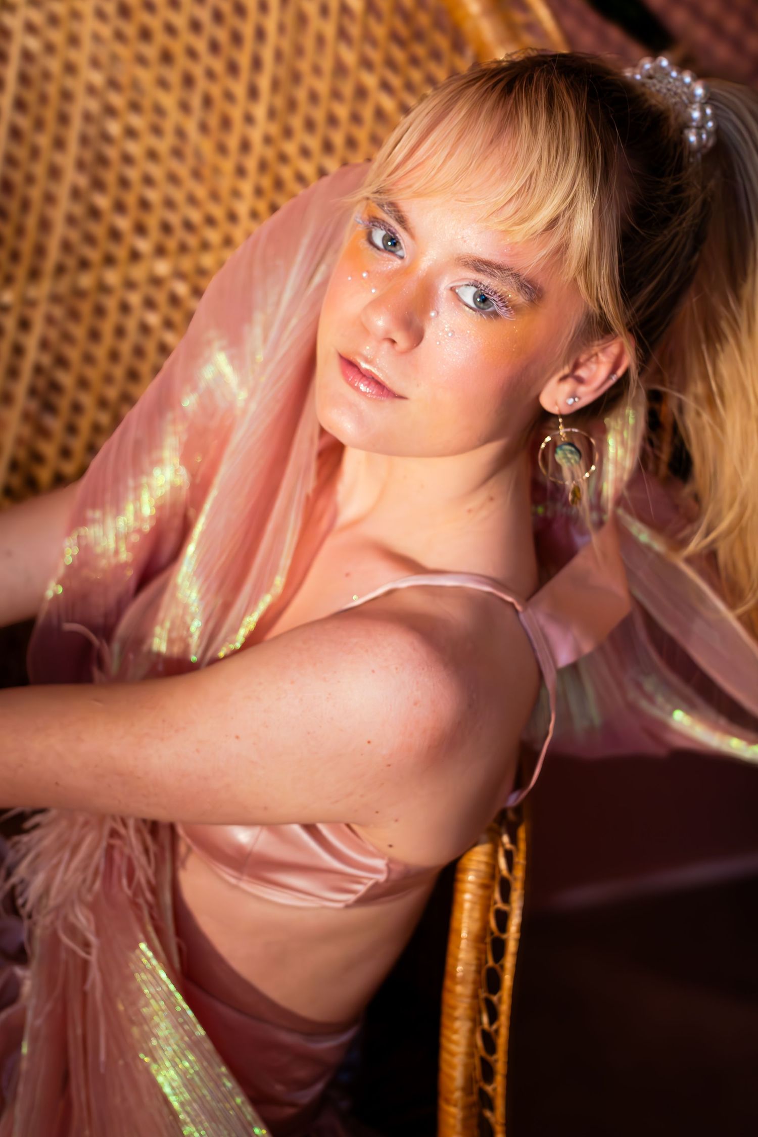 Intimate portrait with iridescent fabric in warm lighting.