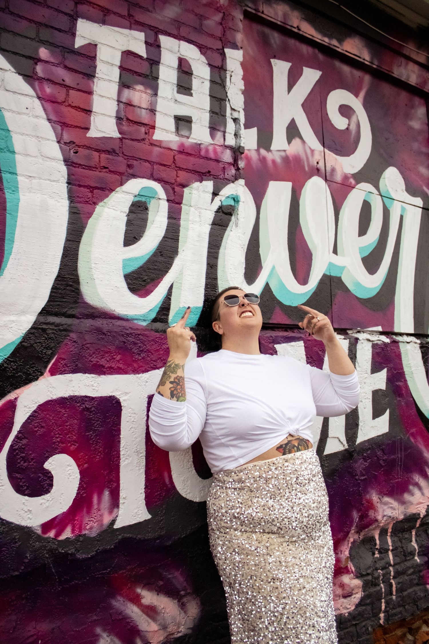 Person in white top and sparkly pants poses expressively against colorful graffiti wall in multiple action shots.