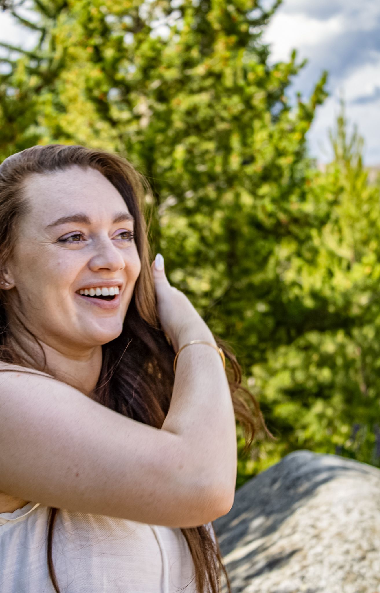 Candid sequence of joyful expressions against green foliage background in natural lighting.