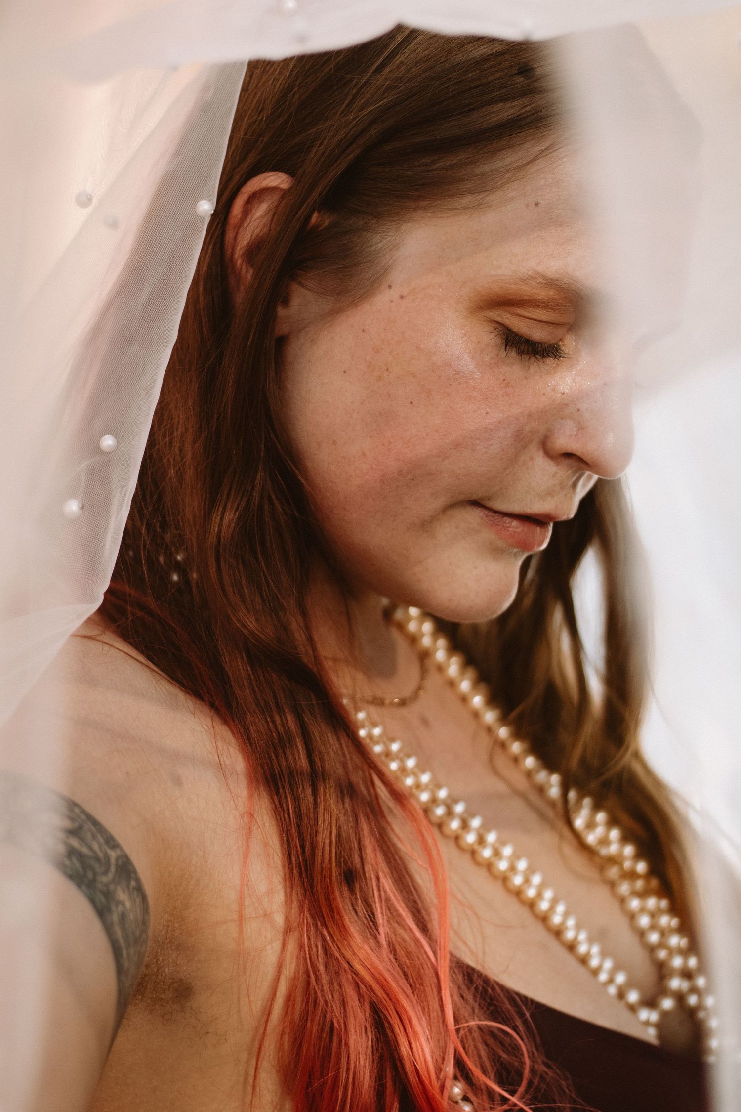A series of five artistic portrait shots showing red hair and a pearl necklace against a light background.
