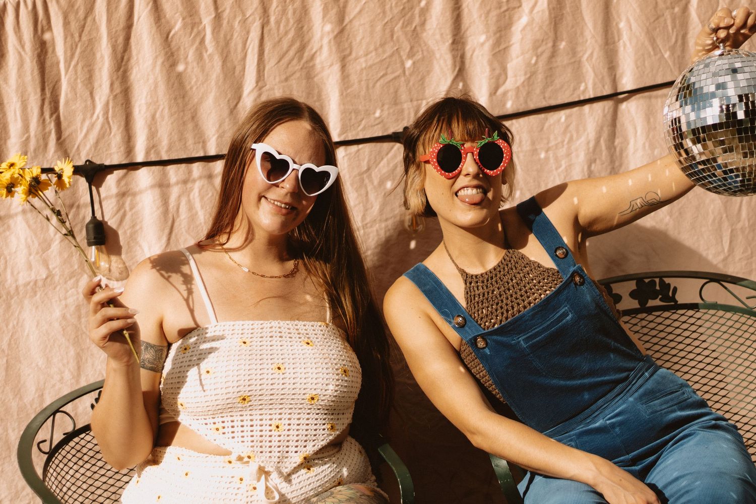 A group of people relaxing on lounge chairs in a row, wearing sunglasses and casual summer attire.