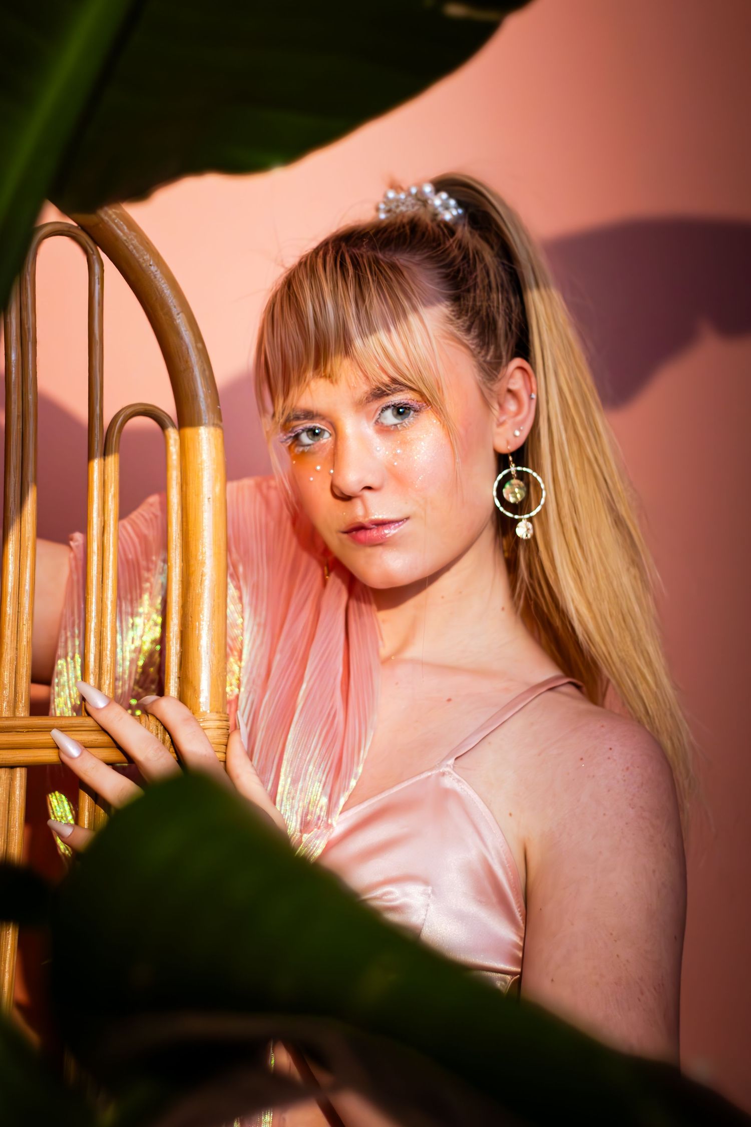 Portrait series with soft pink lighting shows a person posing with candles and dramatic shadows in the background.