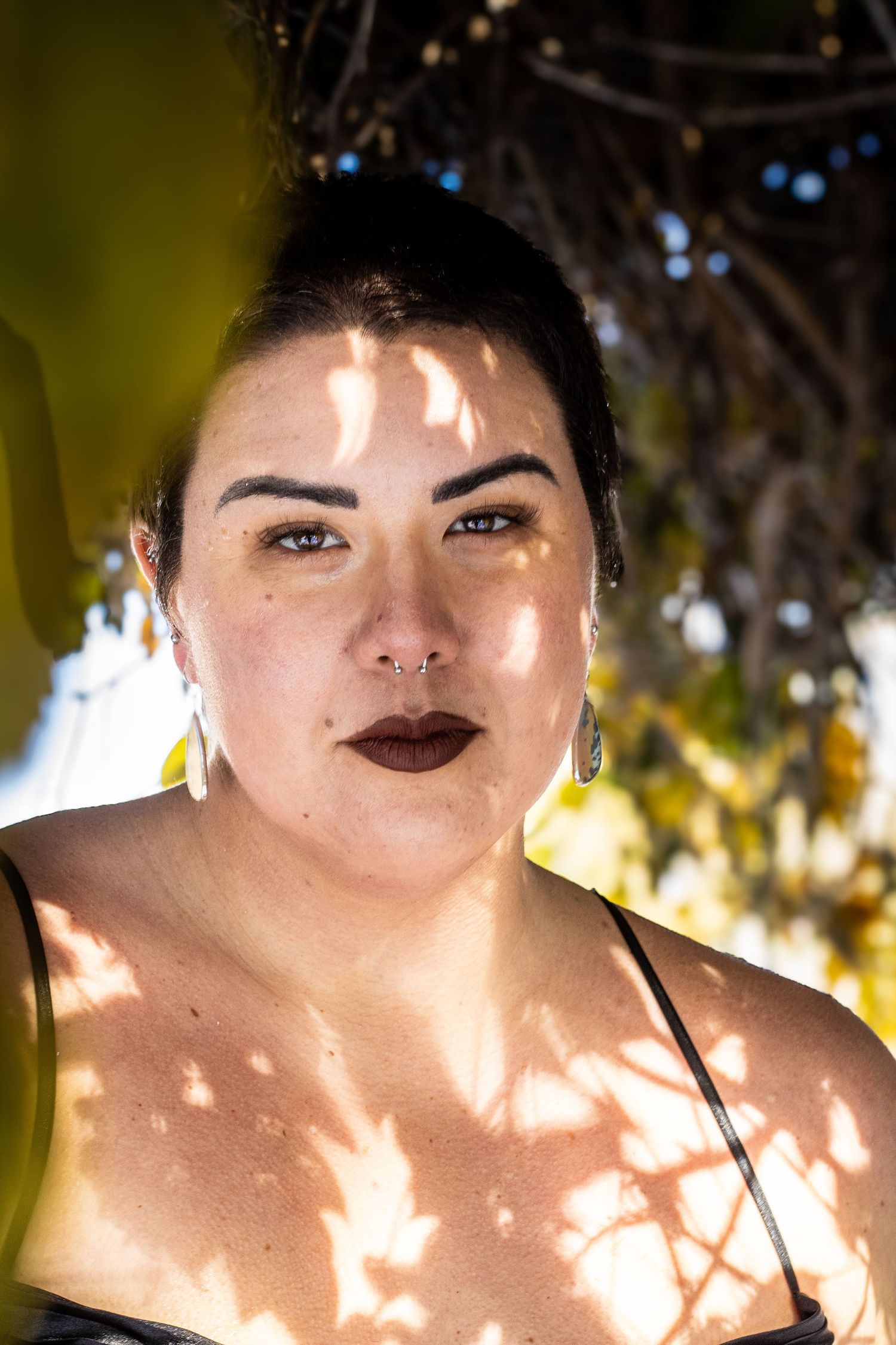 A portrait series showing dappled sunlight and shadows creating patterns on skin in warm natural lighting.