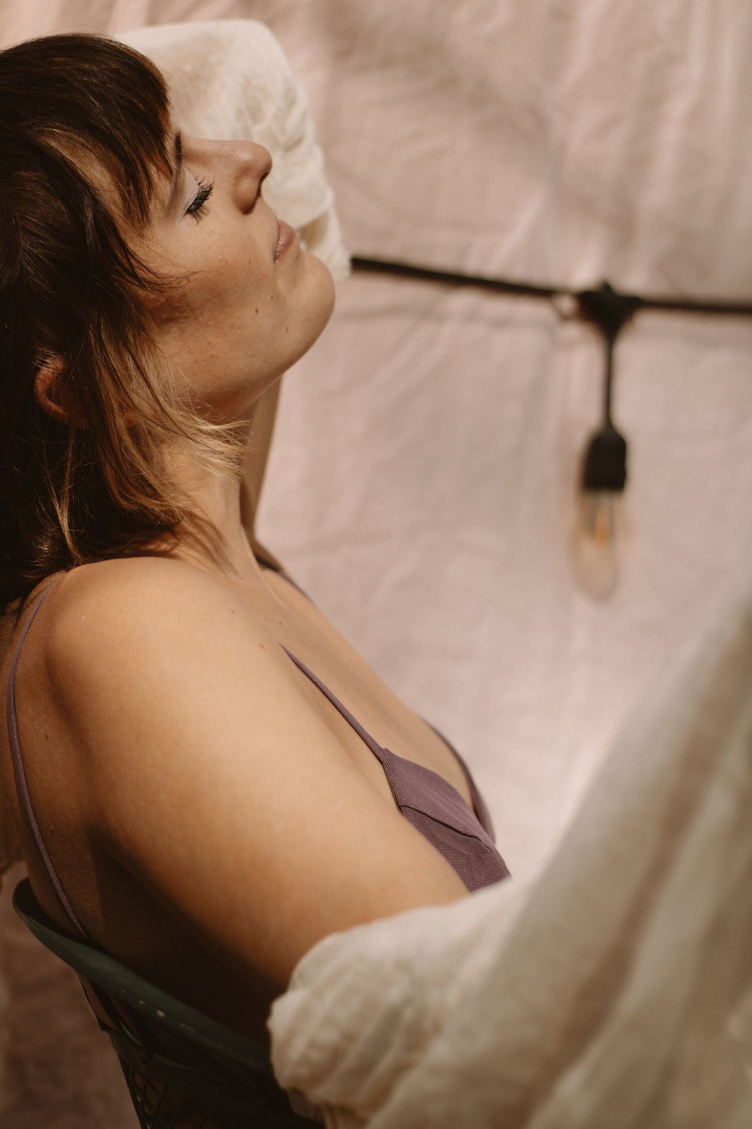 A series of soft, sepia-toned profile portraits showing a person in a sleeveless top against a light background.