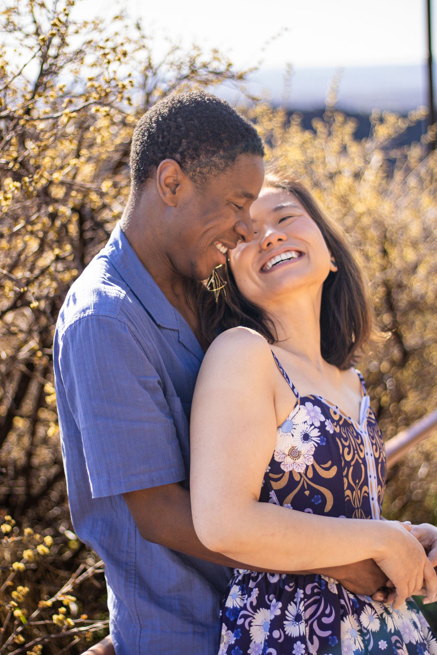 A couple embraces and shares joyful moments together in a scenic outdoor setting during golden hour.
