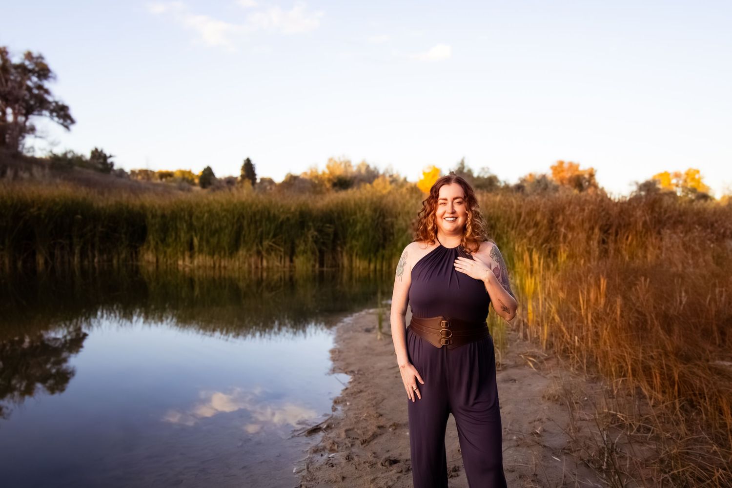 Scenic wetland landscape at sunset with golden reeds and water reflections creating a tranquil outdoor setting.