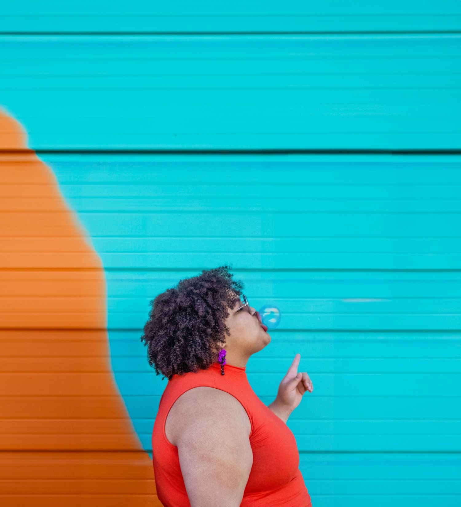 Person in red tank top poses against turquoise wall in dynamic photo series showing movement and expression.