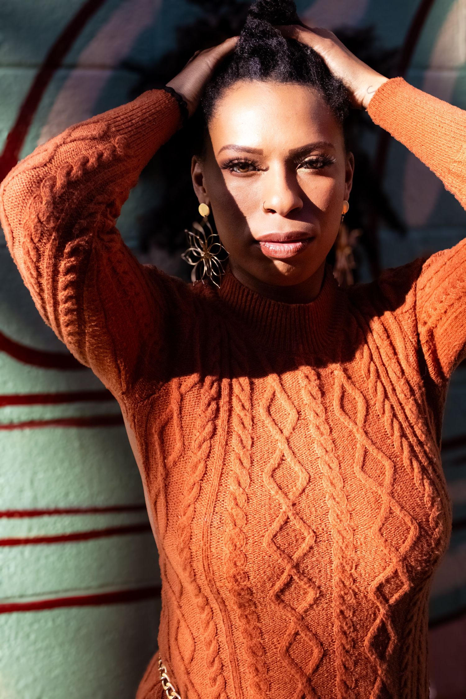 A series of photos showing someone wearing a cozy brown cable knit sweater in warm lighting.