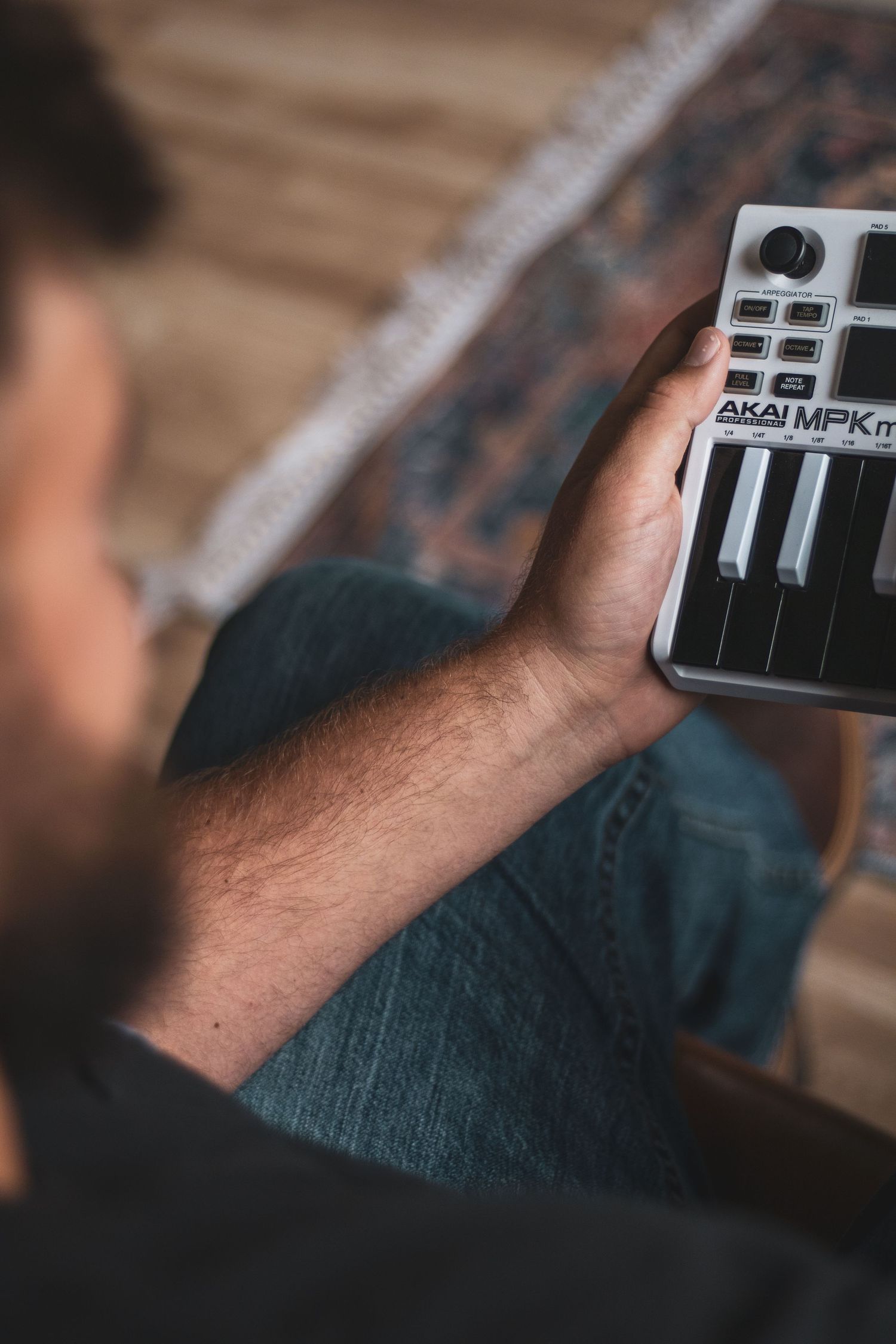 A hand holds a black and white keyboard device in a dimly lit setting showing multiple sequential shots of movement.
