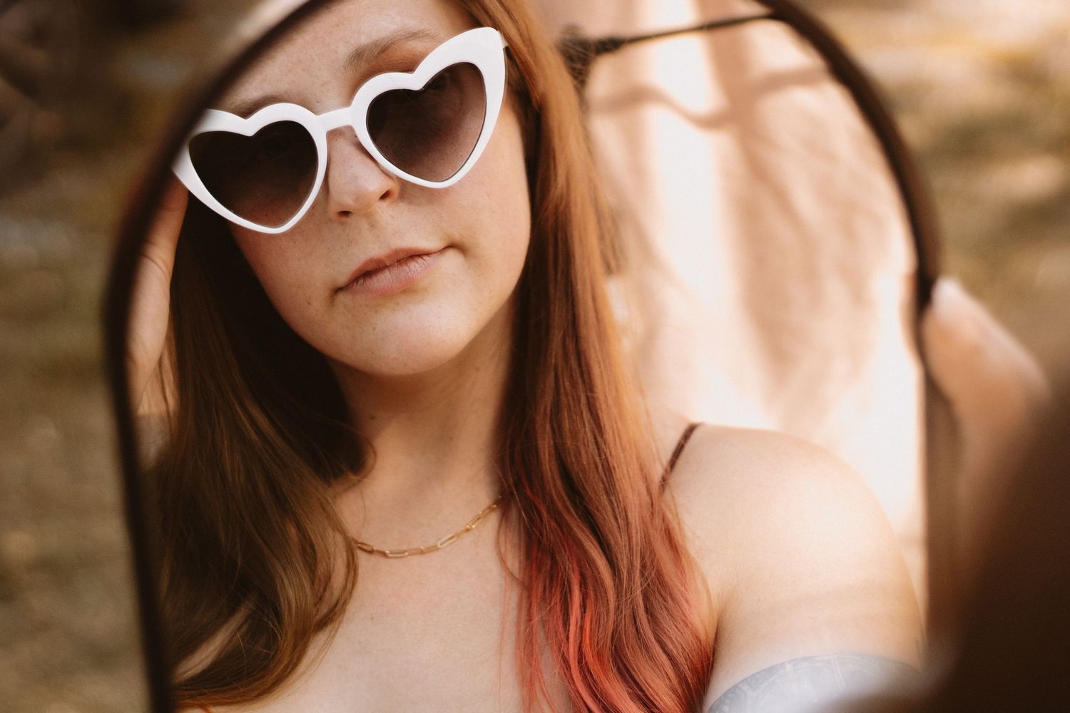 A series of candid outdoor portrait shots showing someone in heart-shaped sunglasses and a red top.