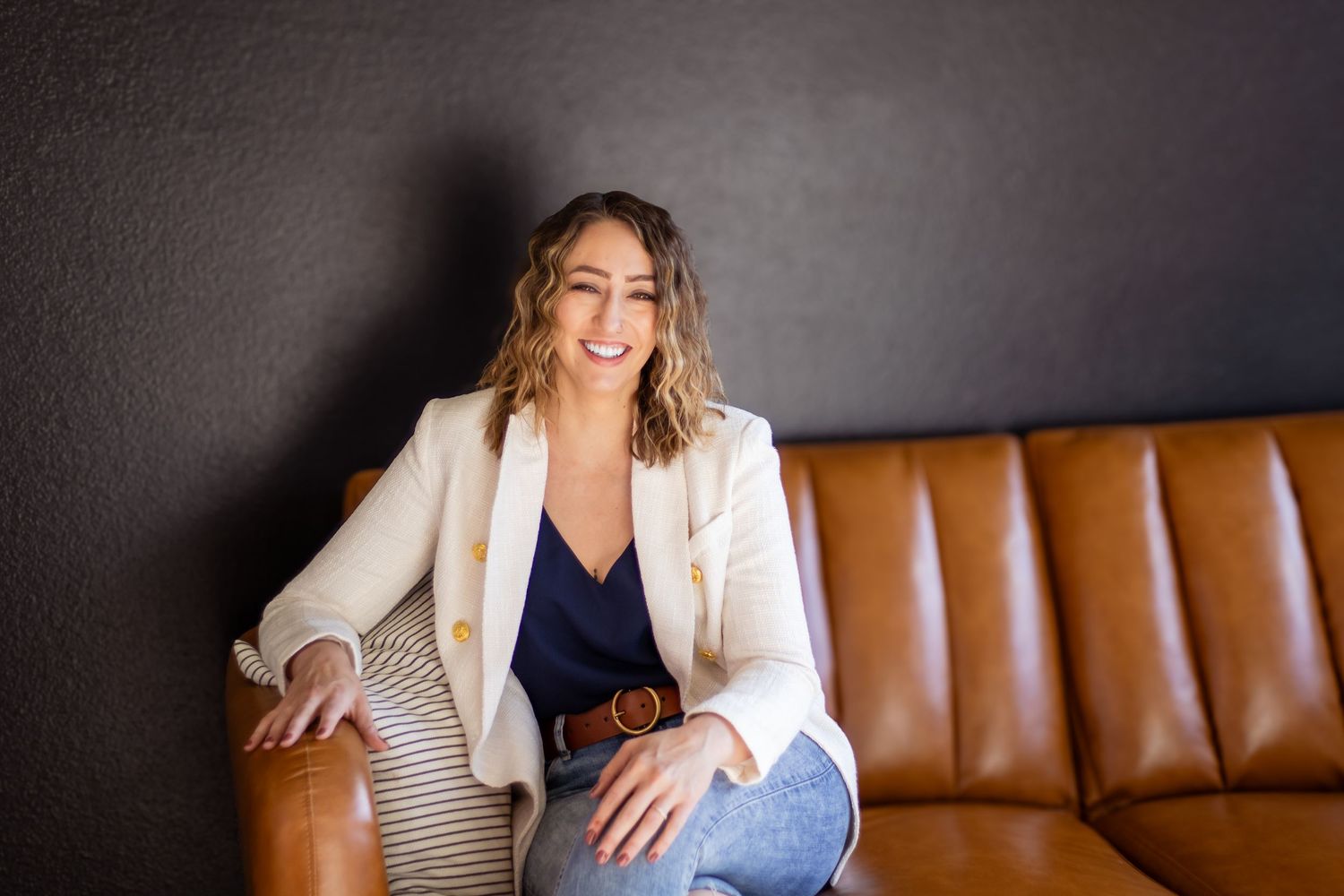 Professional lifestyle photography series showing relaxed poses on a brown leather couch in a studio setting.