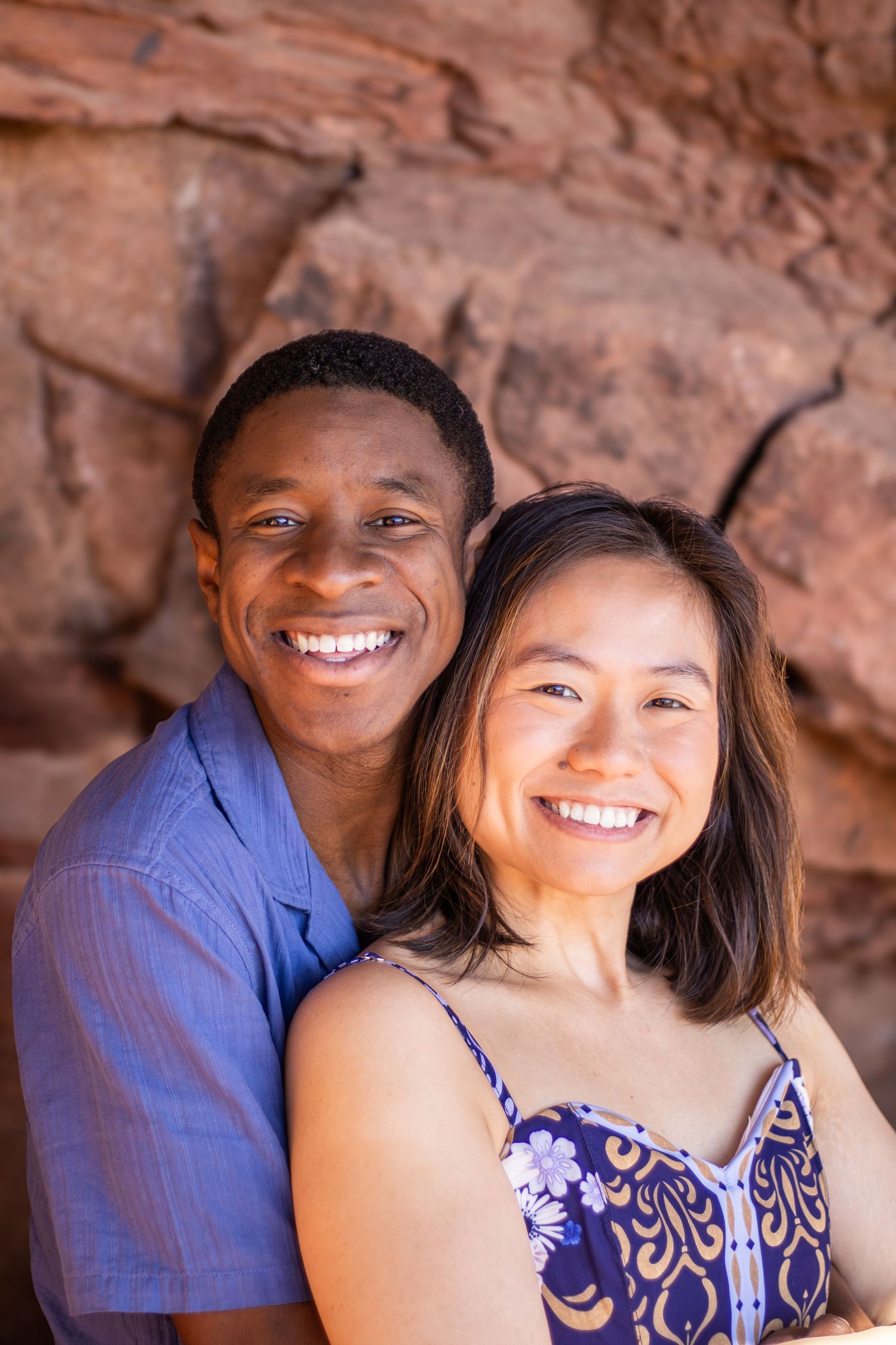 Two people smile together while posing in front of red rock formations in a series of candid photos.
