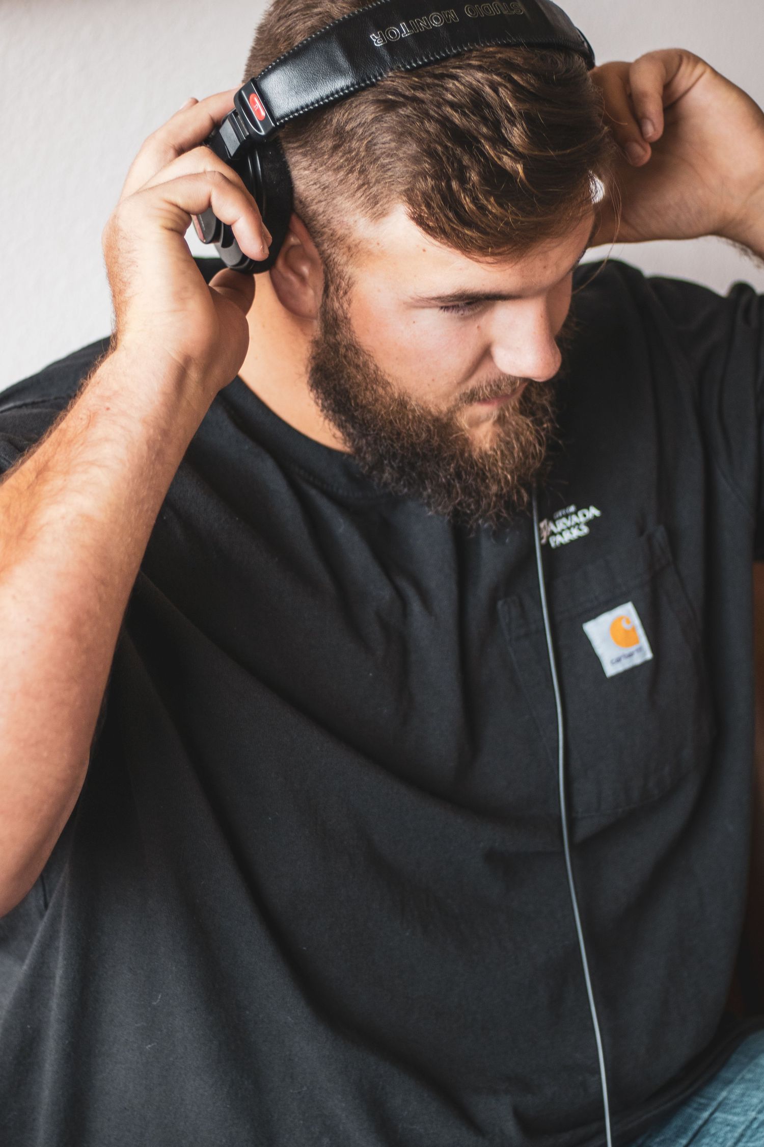 Person wearing black shirt and headphones shown in a series of cropped detail shots focusing on the headphone usage.