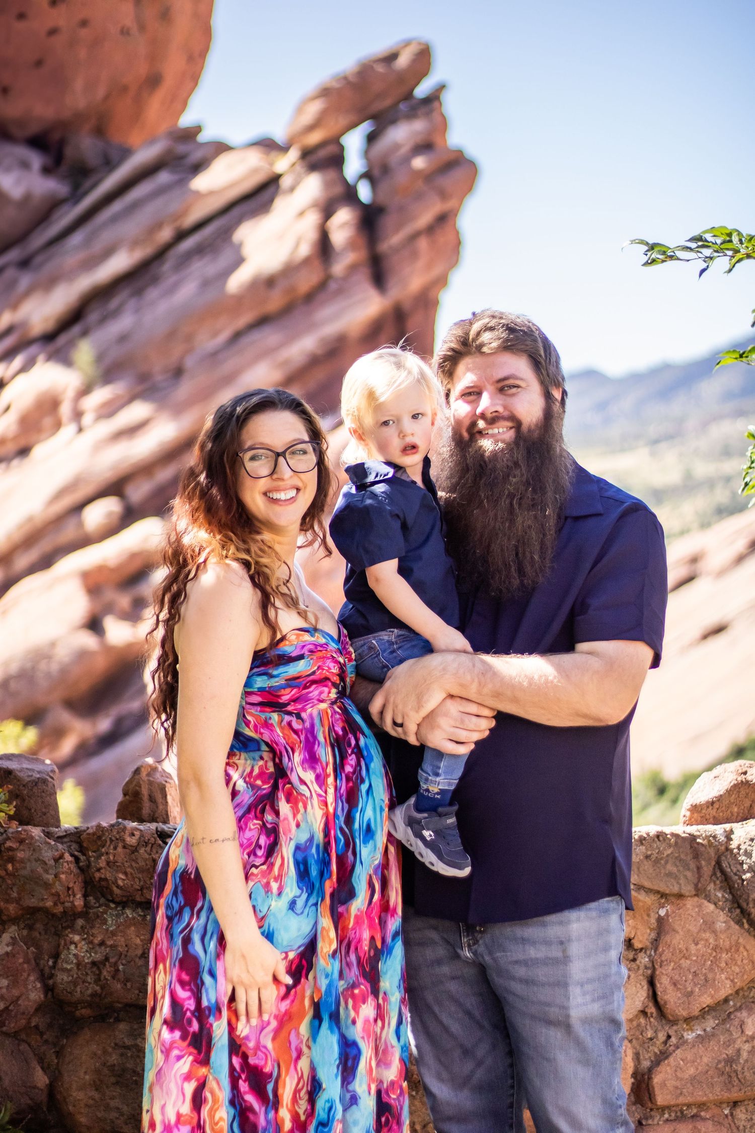 A couple shares joyful moments together against red rock formations at sunset.